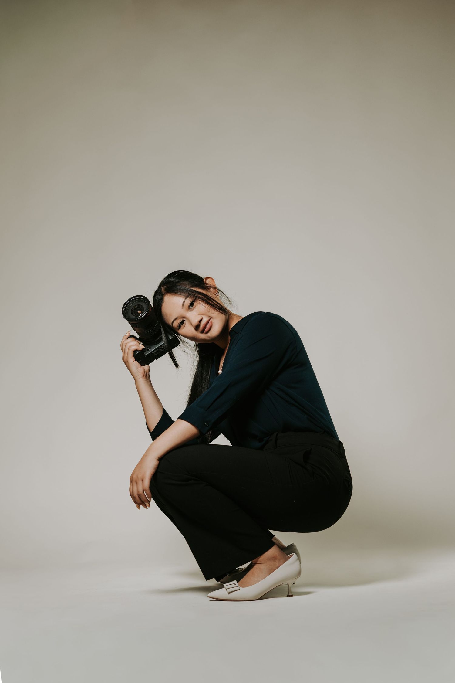 A figure in black clothing performs a series of graceful poses against a neutral studio backdrop.