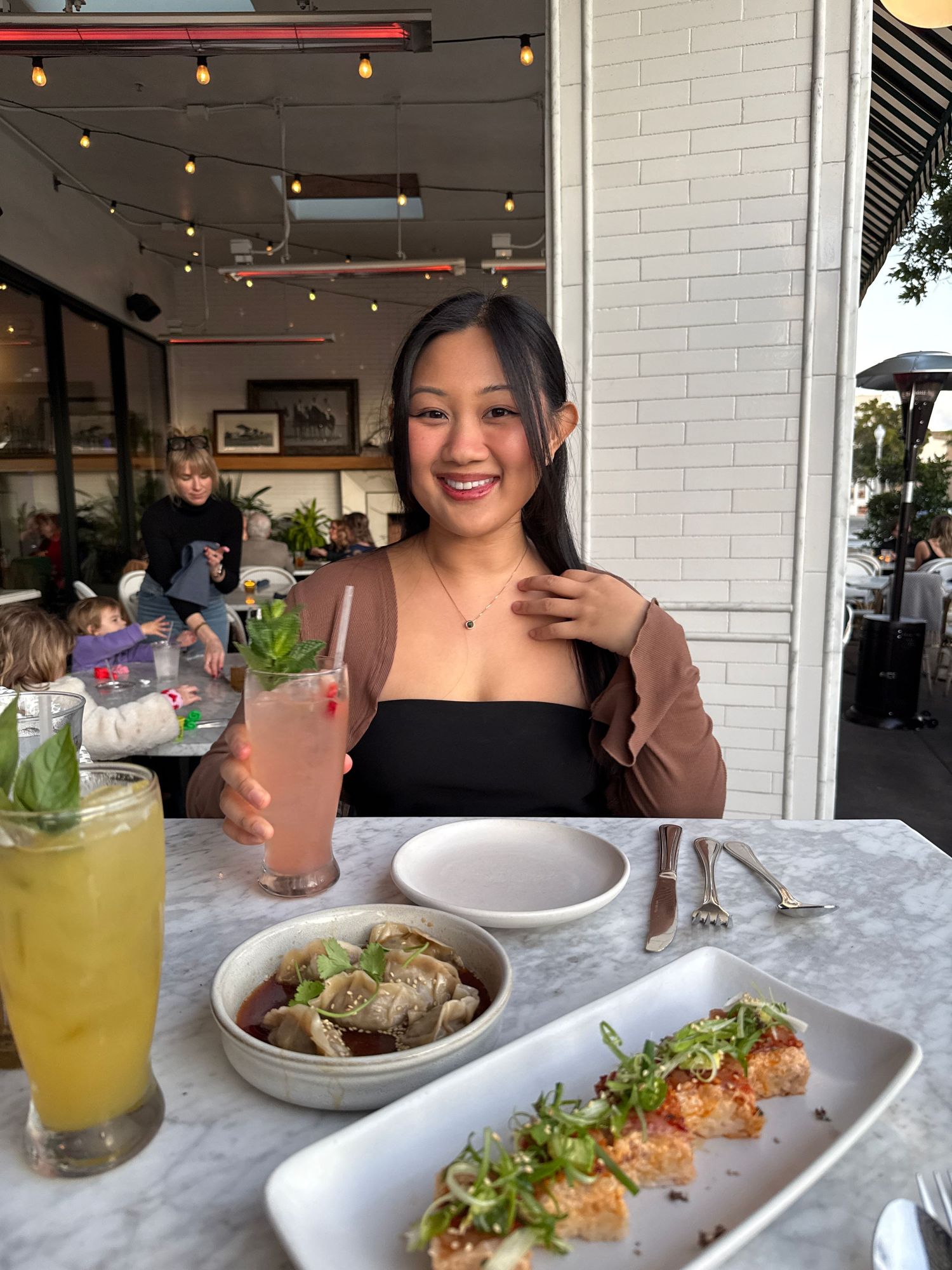 Restaurant table set with colorful drinks and elegant plated dishes including salmon.