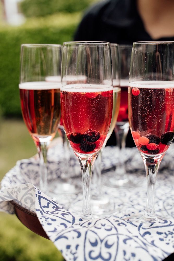 Elegant champagne flutes filled with sparkling pink wine arranged on decorative blue and white patterned napkins.