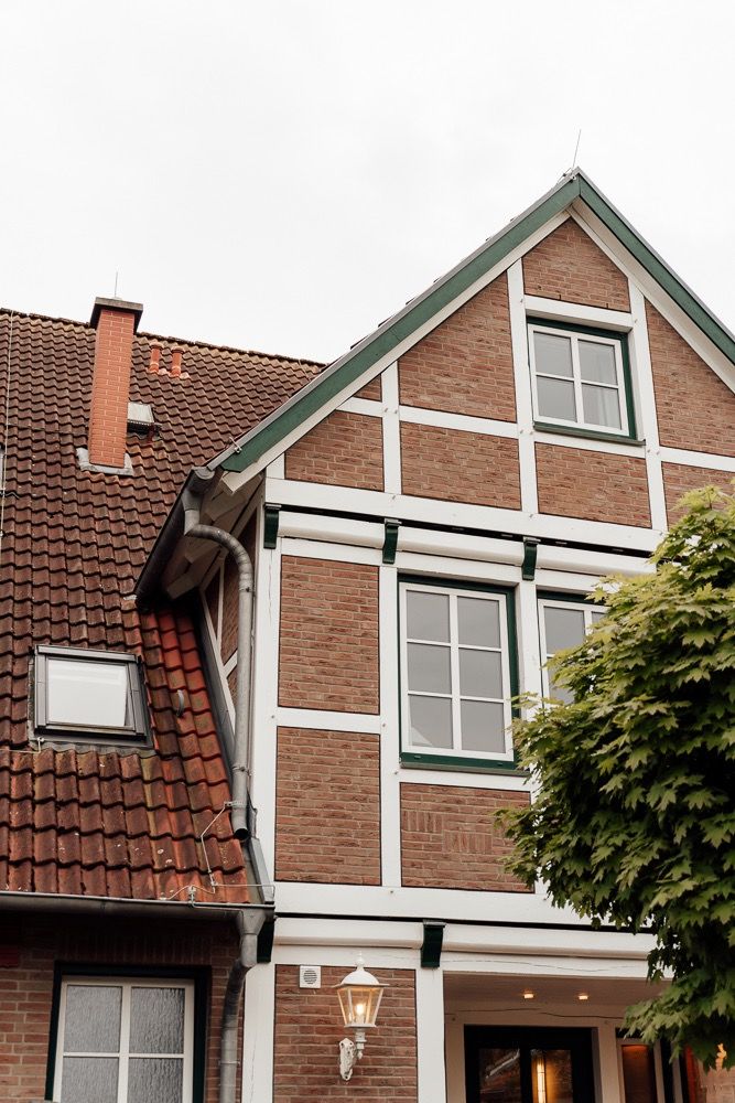 Modern brown brick townhouses with white trim and gabled roofs line a residential street.