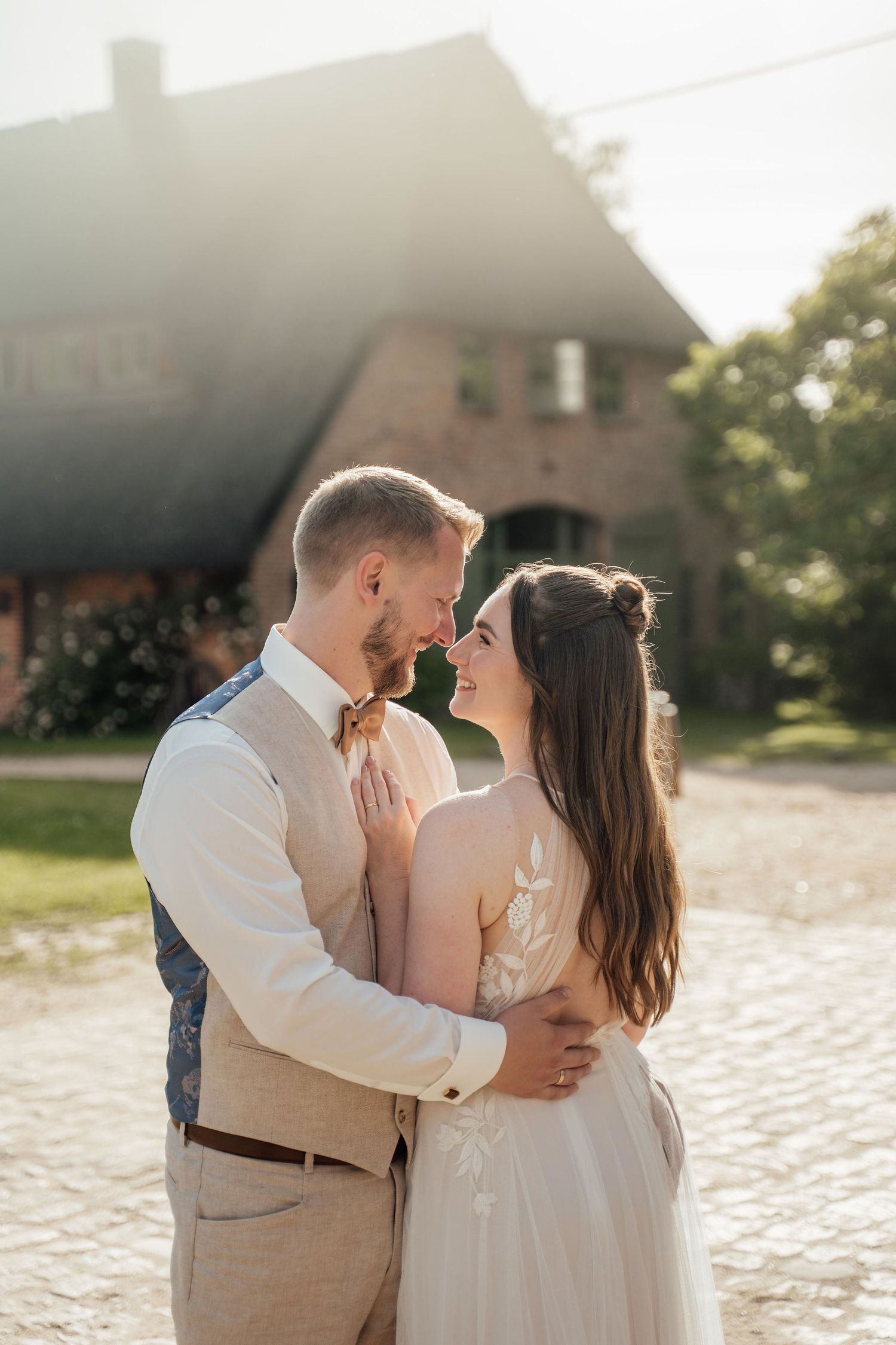 Ein Hochzeitsshooting bei Sonnenuntergang auf Kopfsteinpflaster mit zärtlichen Momenten und warmem, goldenem Licht.