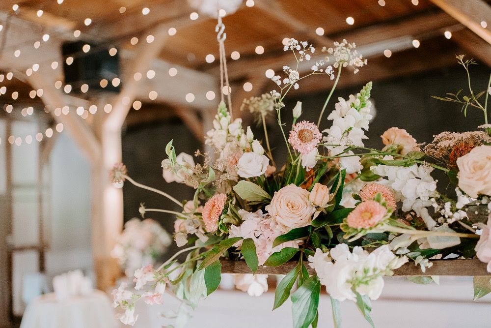 Elegant floral arrangements with pink and white blooms adorned with string lights creating a romantic atmosphere.