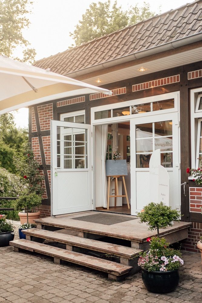 Modern brick house with white trim features a spacious wooden deck and large windows along the exterior.