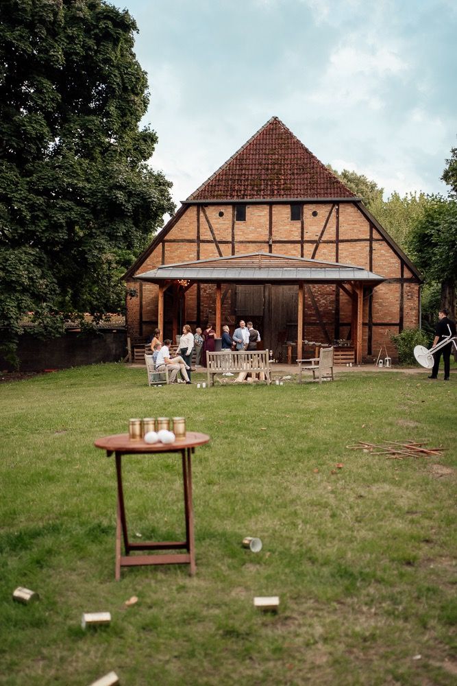 A series of outdoor photos showing a rustic barn venue with timber framing and a grassy lawn setup for a countryside event.