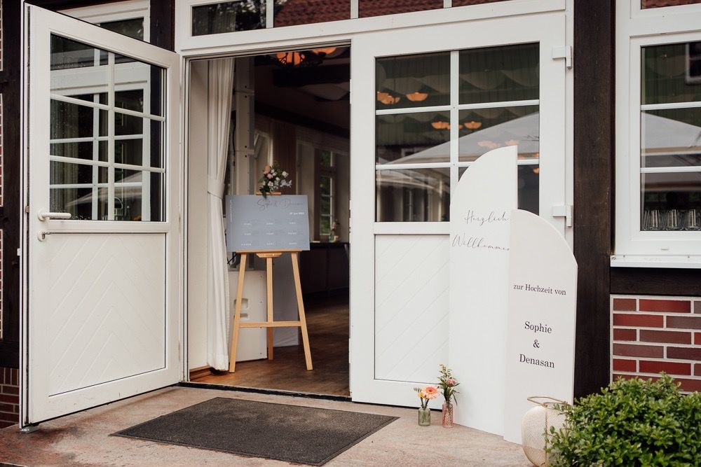 Modern white-framed glass doors and windows on a brick building exterior with green landscaping.