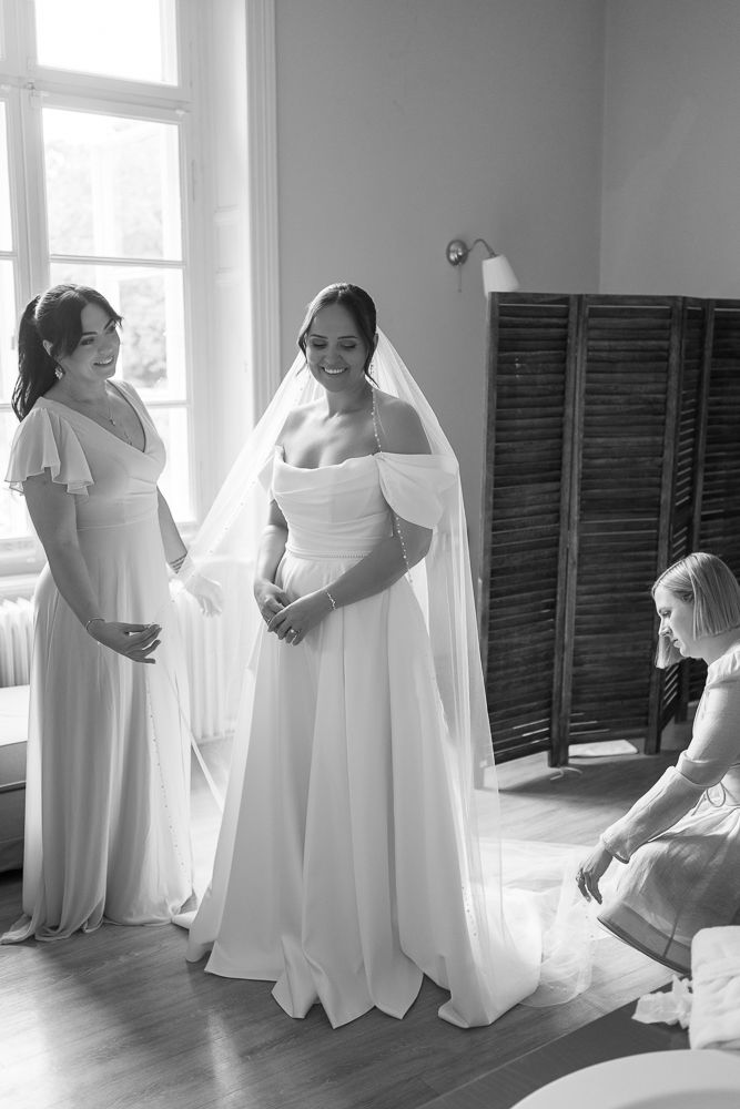 A series of black and white photos showing the preparation process of a bride getting dressed for her wedding day.