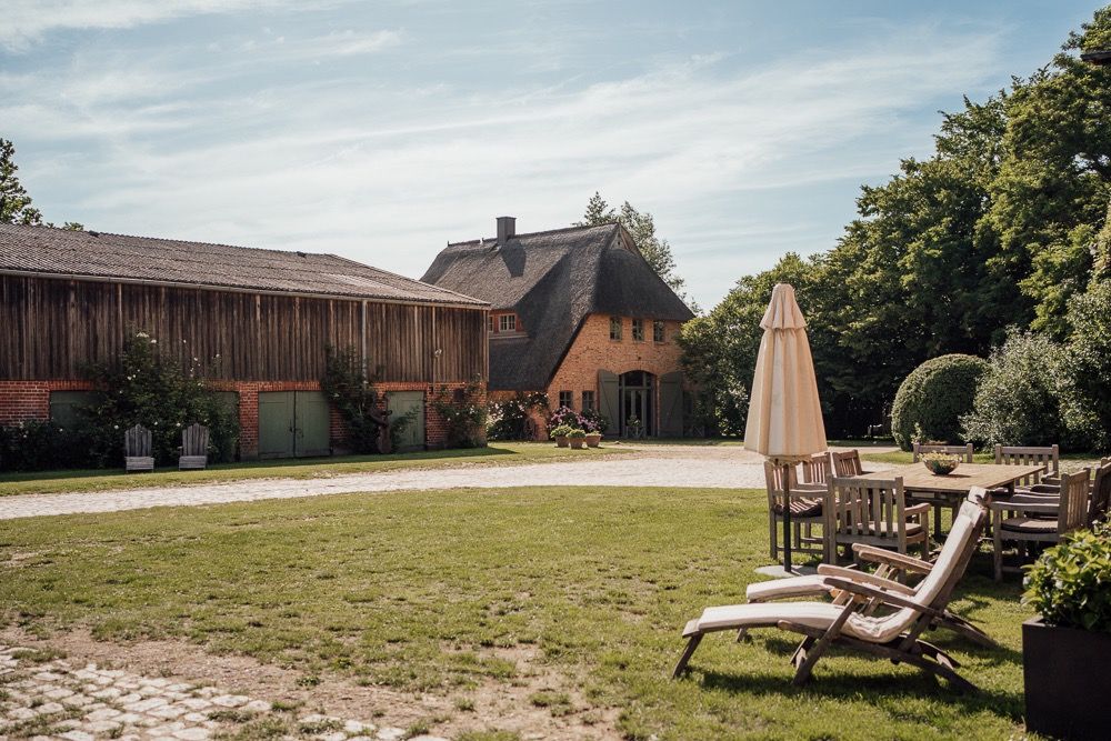 Panoramic view of a rustic barn venue with rolling hills and outdoor seating areas in the countryside.