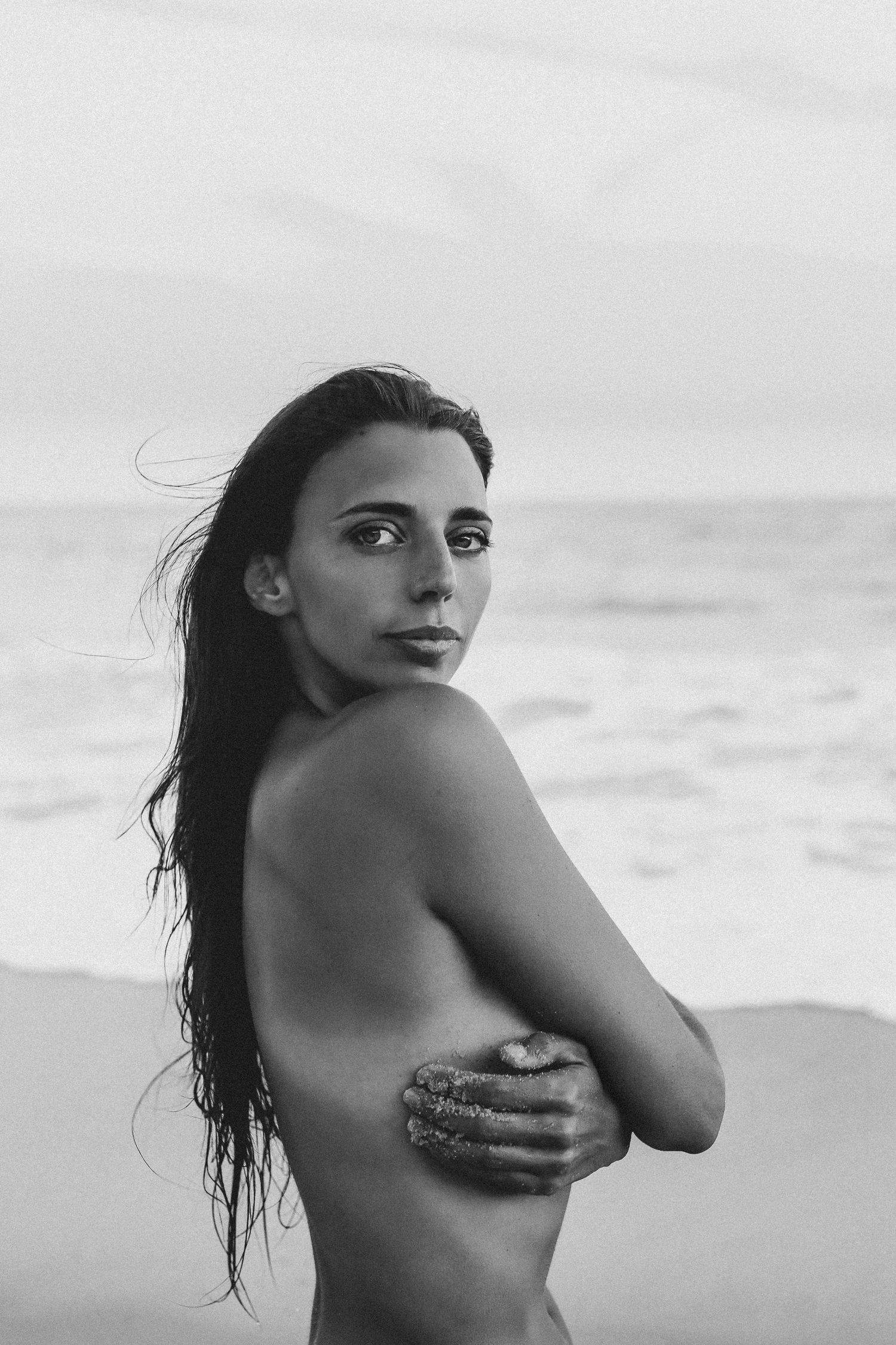 Sfeervol boudoir beeld op het strand met focus op de essentie van de vrouw, precies zoals ze is.