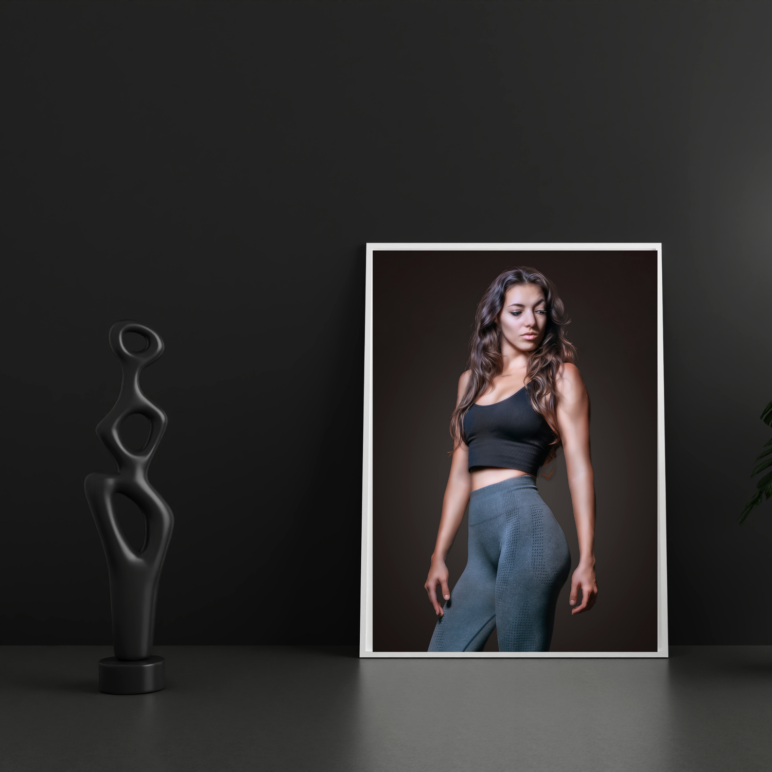 A framed portrait photo of a woman in athletic wear leaning against a dark wall beside a black abstract sculpture.