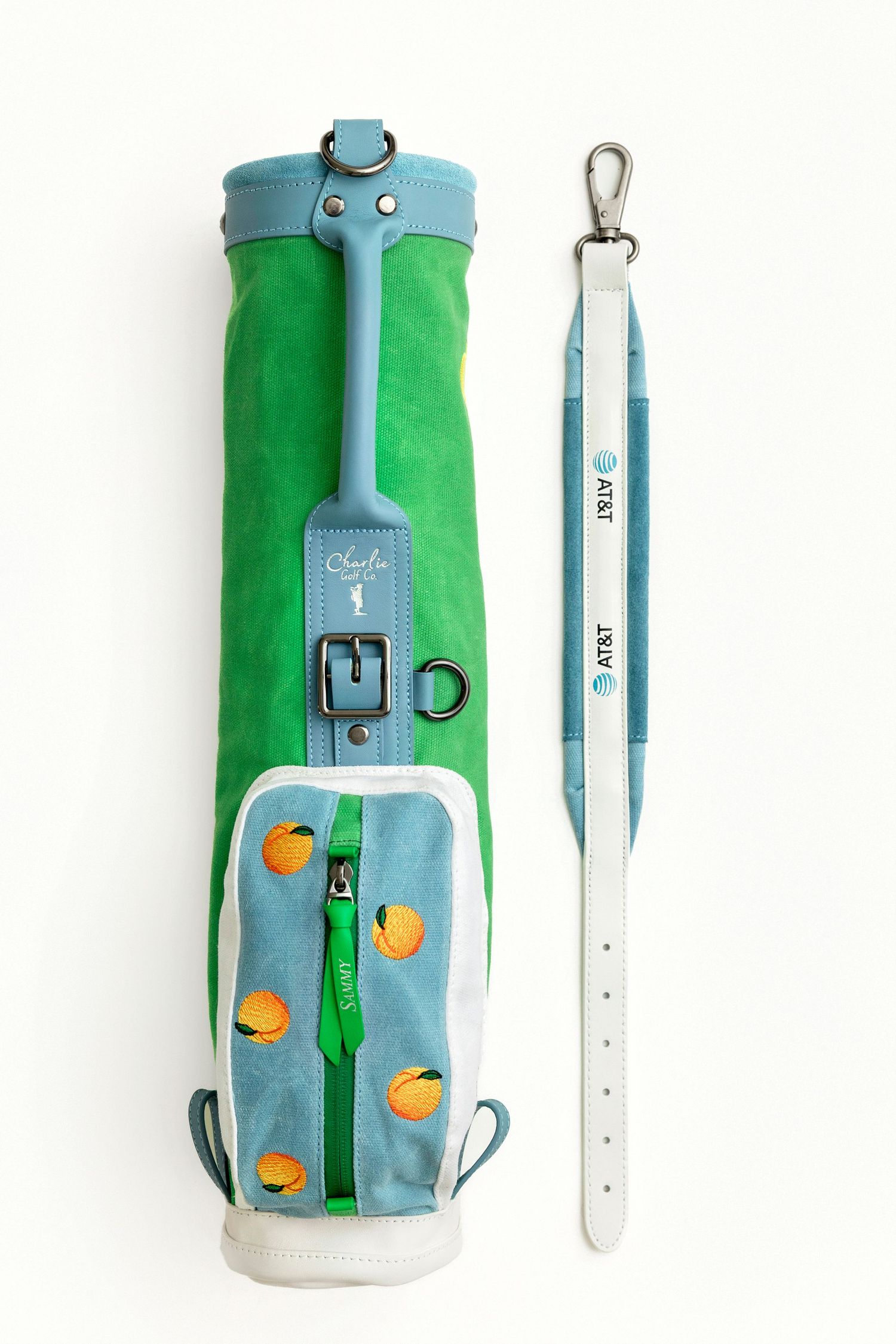 Green and blue AT&T branded golf bag with orange fruit embroidery and matching white leather strap.