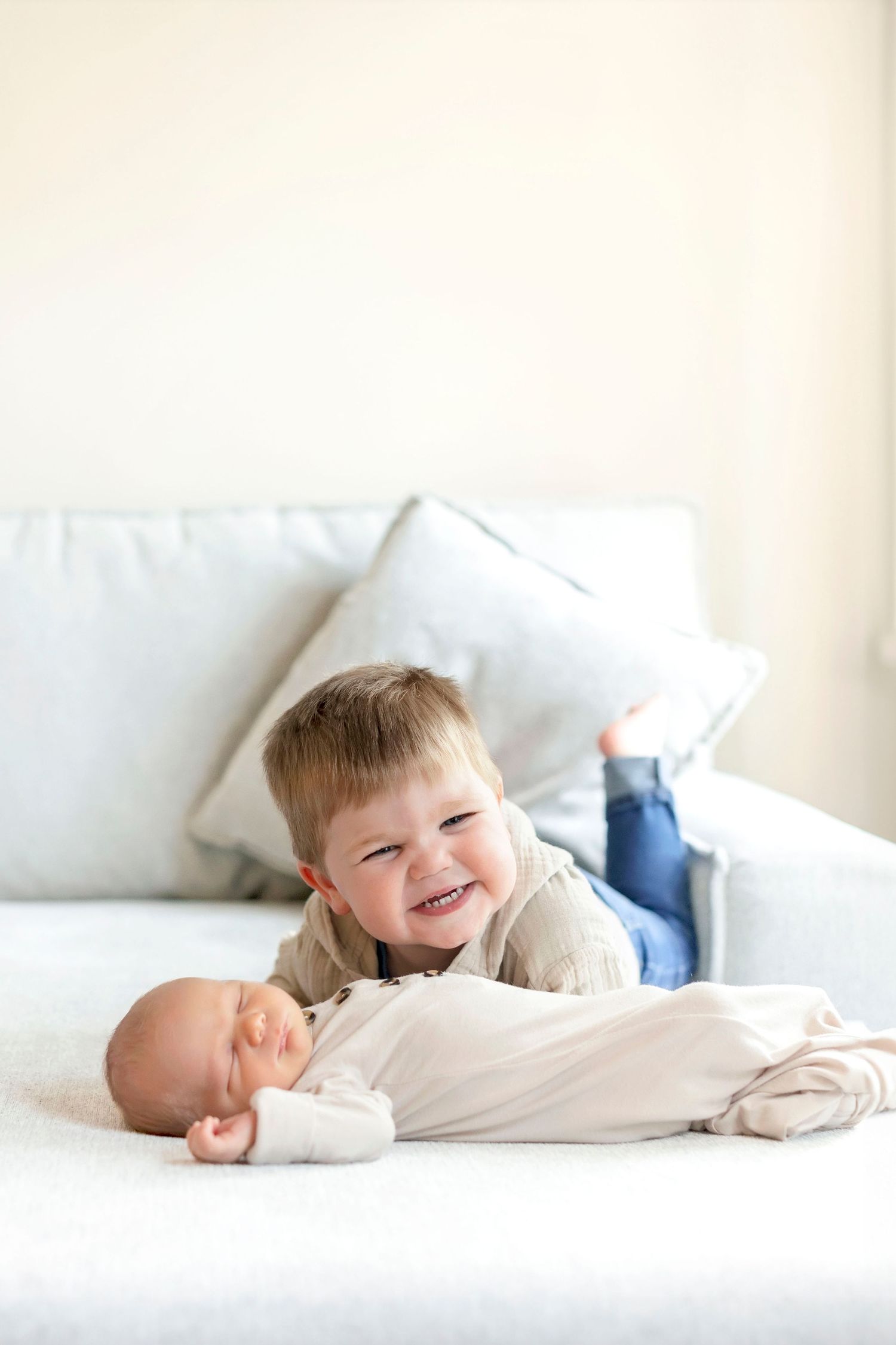 Big brother holding newborn during a lifestyle newborn photography session in Clear Lake home.