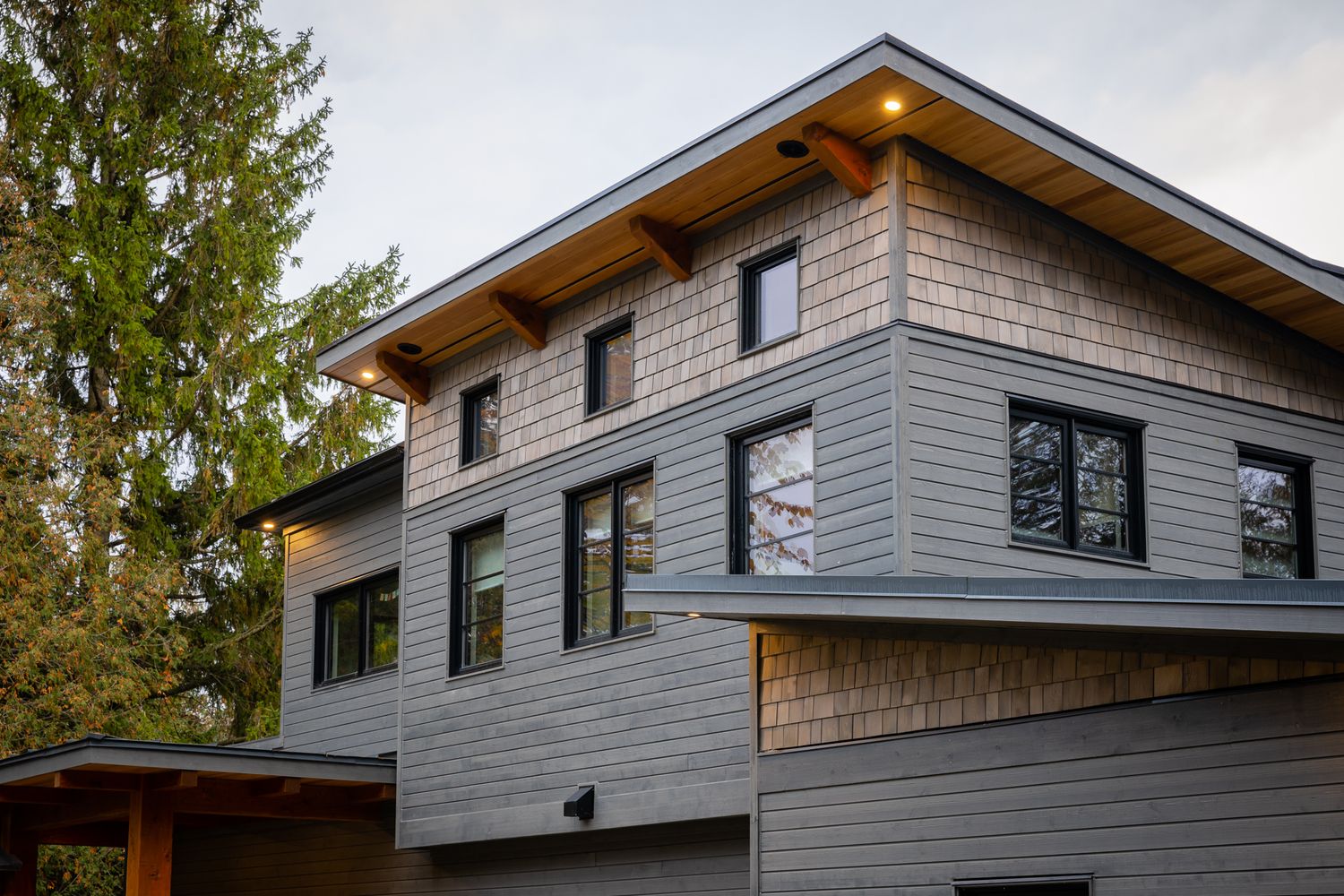 This house features wood siding and cedar shake siding with a cedar soffit and black windows.