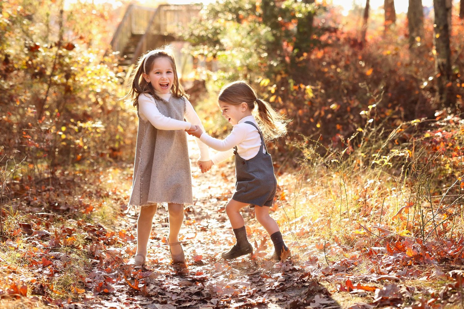 brother and sister joyfully playing in a sunlit autumn forest path at Bunker Hill Bog, Ocean County during golden hour