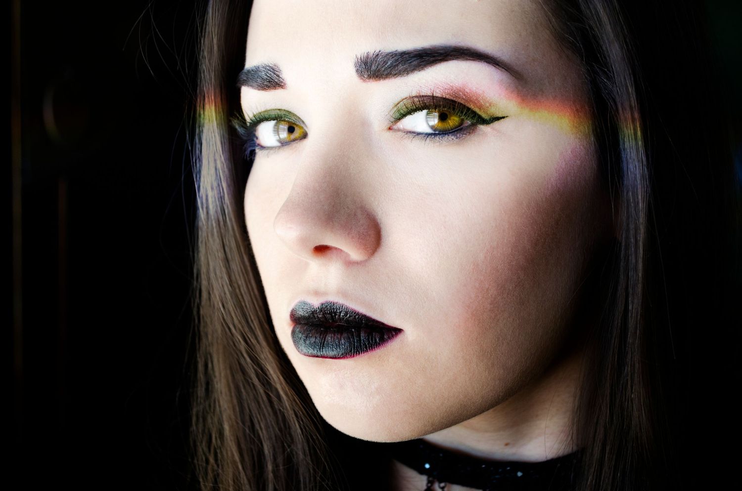 Close-up beauty portrait showing dramatic dark lipstick and smokey eye makeup in moody lighting. Creative portrait photography Las Vegas