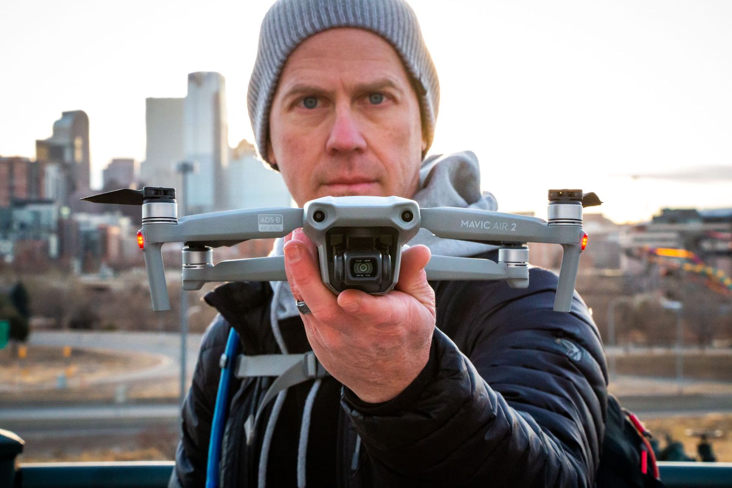 Denver Hospitality, Travel & Tourism photographer Captain Colorado Photography holding his drone in front of downtown Denver, Colorado.