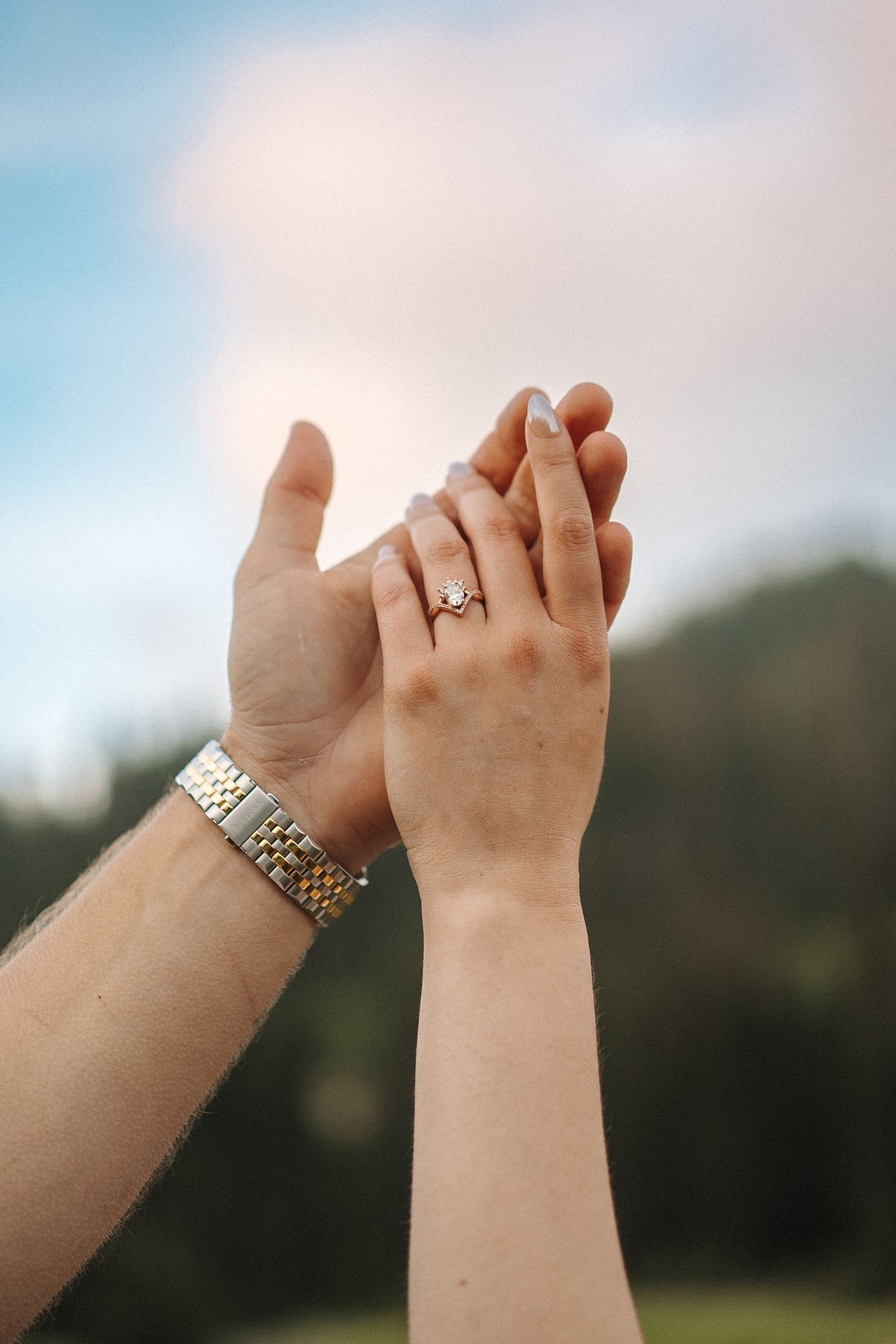 A series of photographs showing hands raised against a blurry sky background, displaying jewelry and rings.