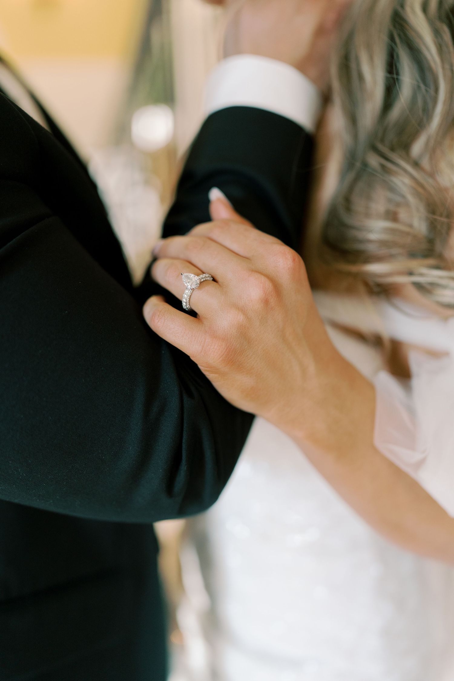 Close-up details of wedding rings and romantic gestures between couple.