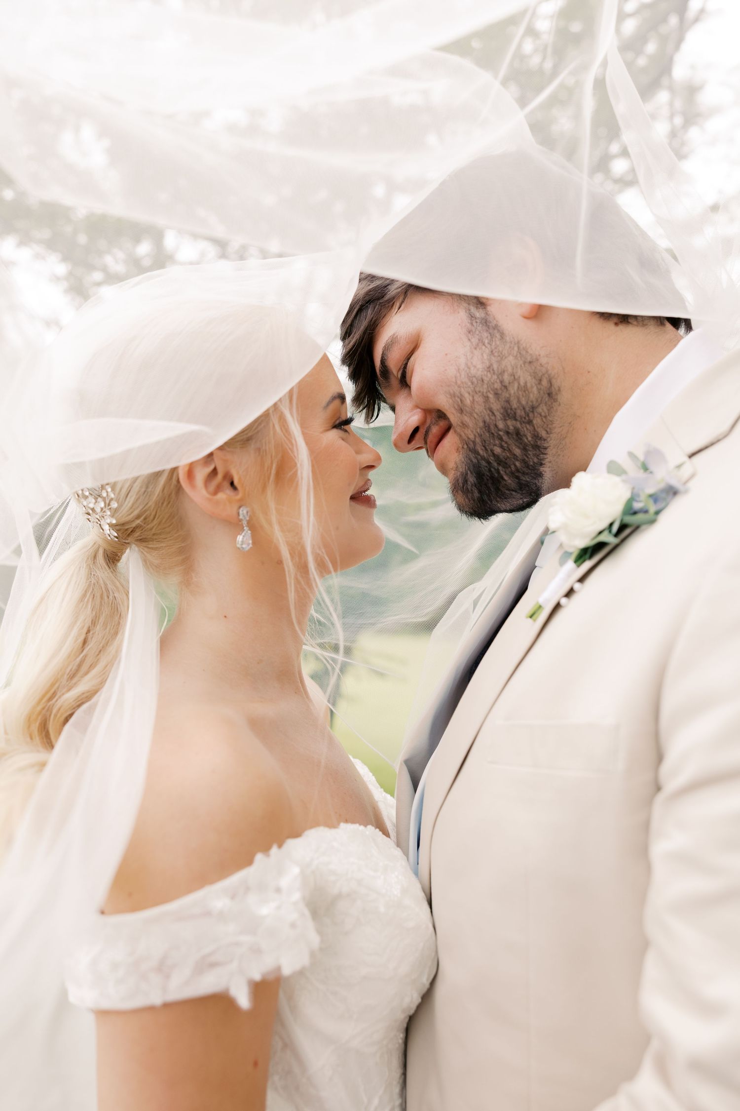 Close-up of wedding couple sharing intimate moment with flowing veil.