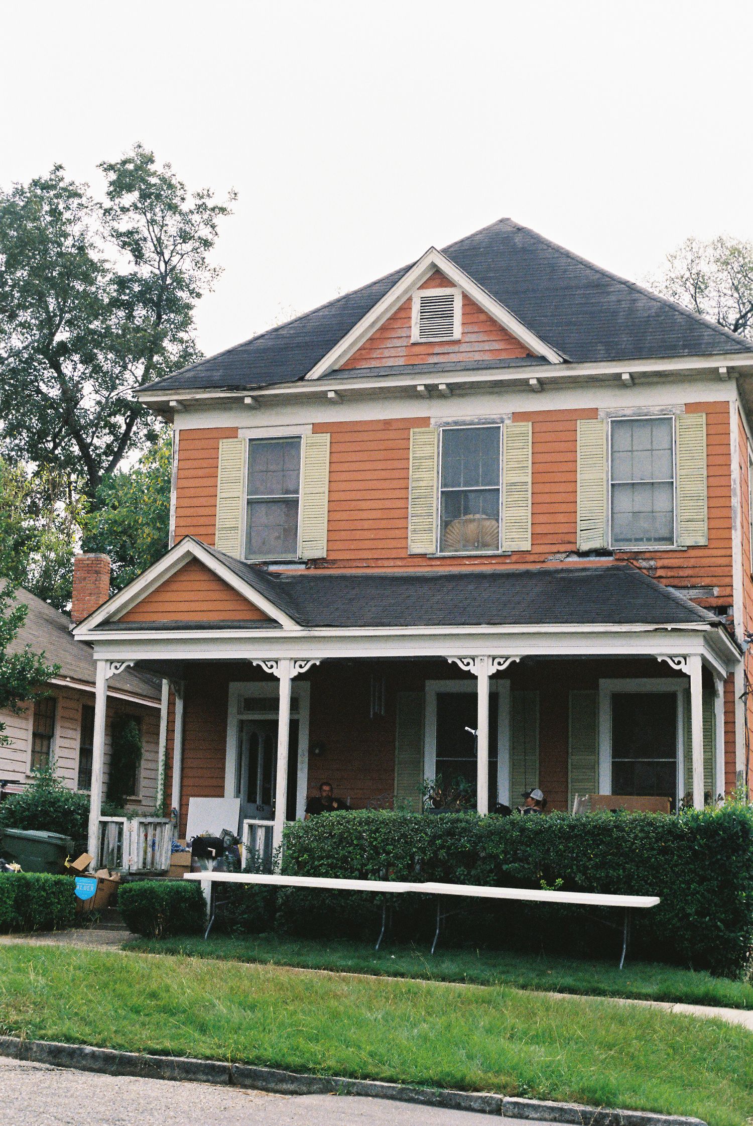 Orange Victorian-style house with white trim and wraparound porch viewed from different angles.