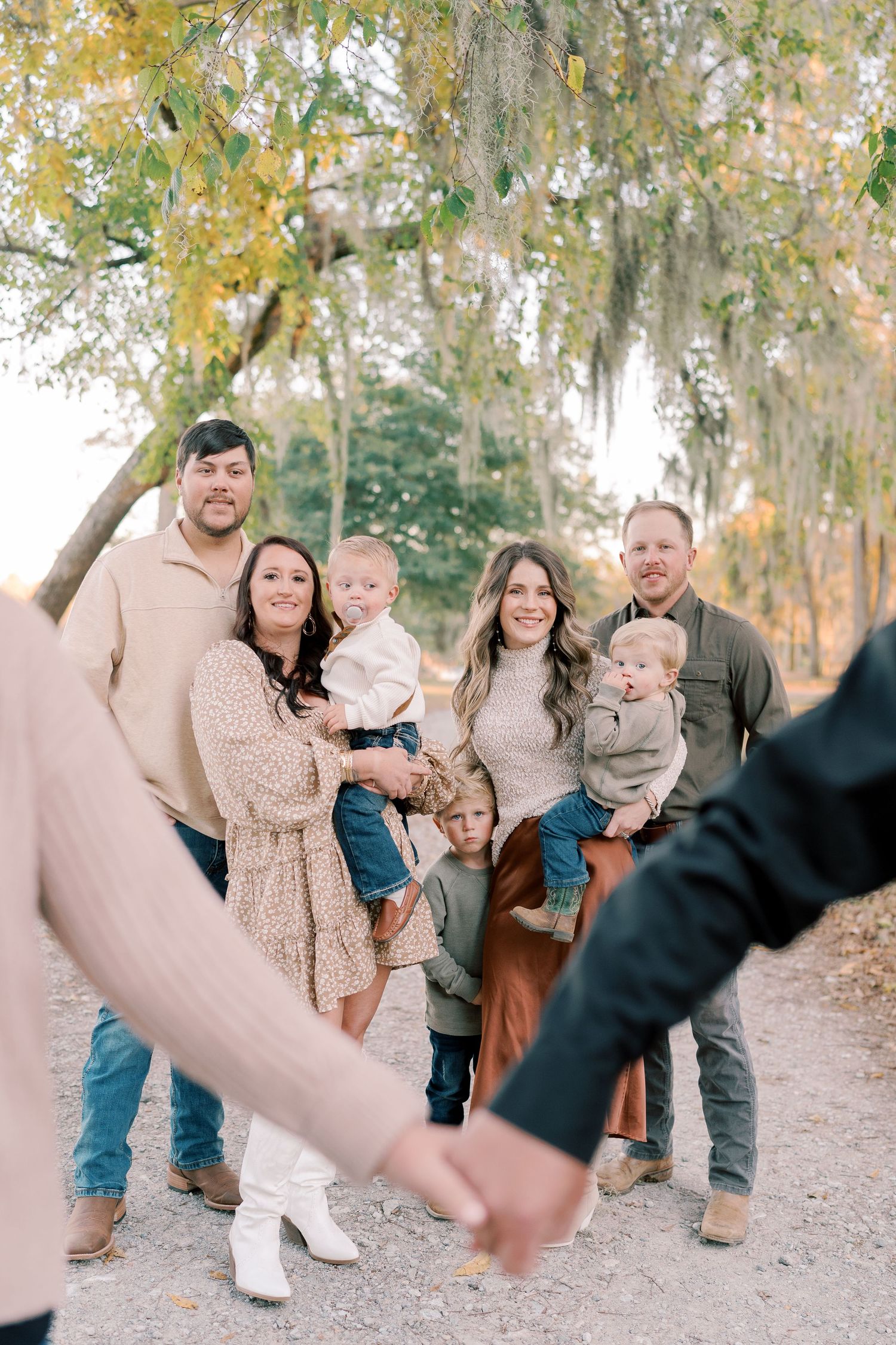 Multi-generational family portrait captured on a scenic autumn trail with Spanish moss overhead.