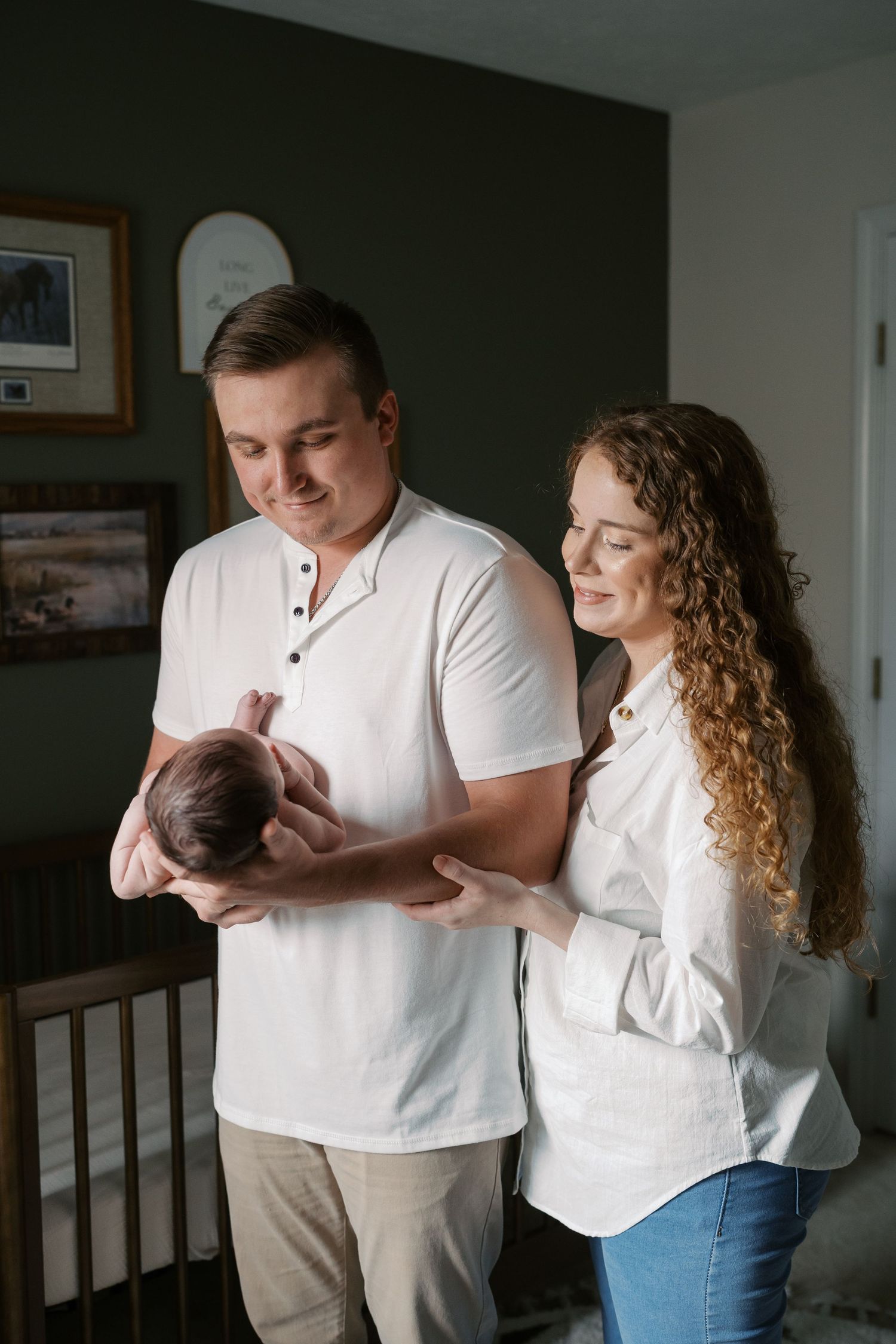 A tender moment captured indoors with soft natural lighting and white clothing.