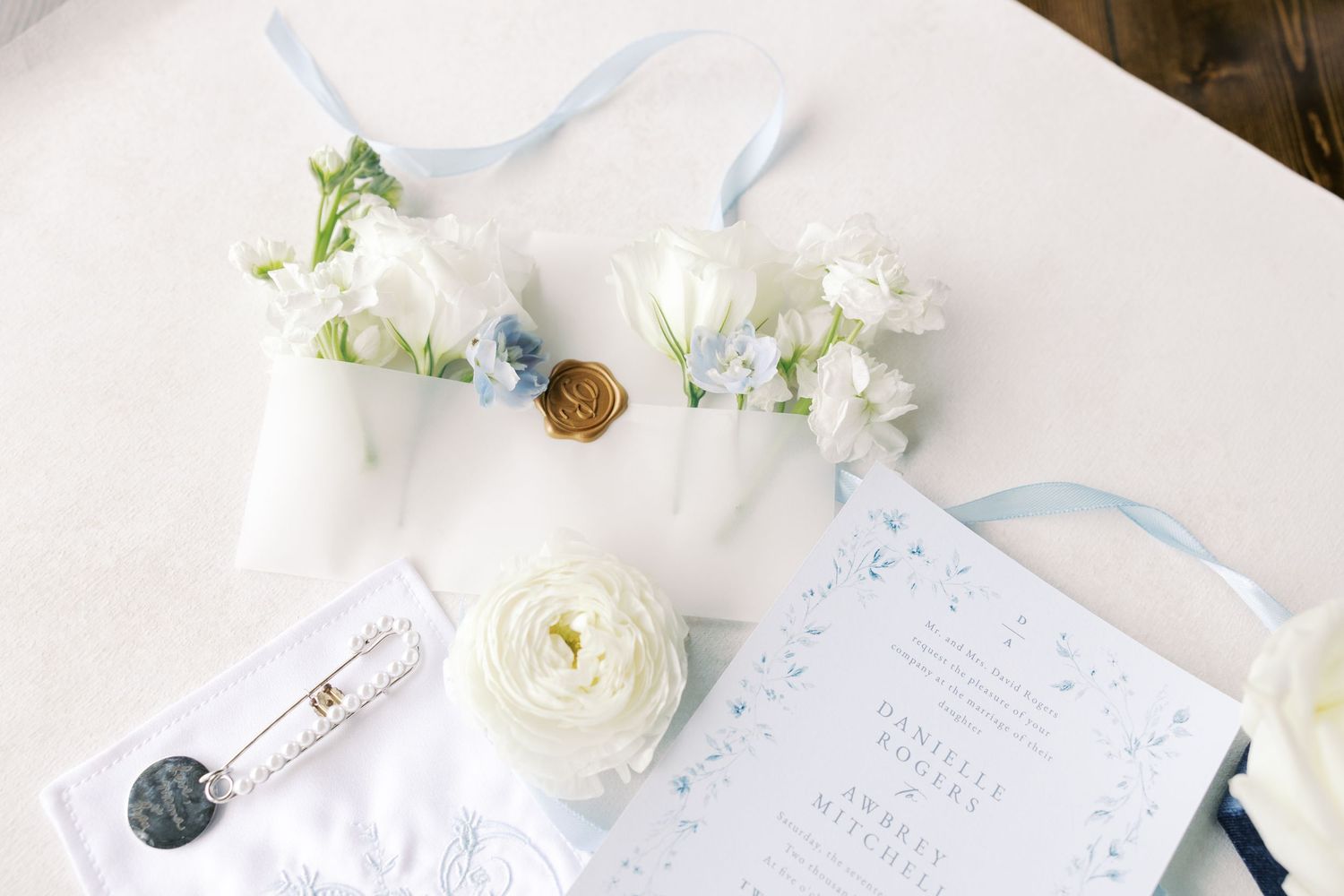 Elegant white bridal shoes and floral arrangements with delicate white flowers and greenery on a light background.