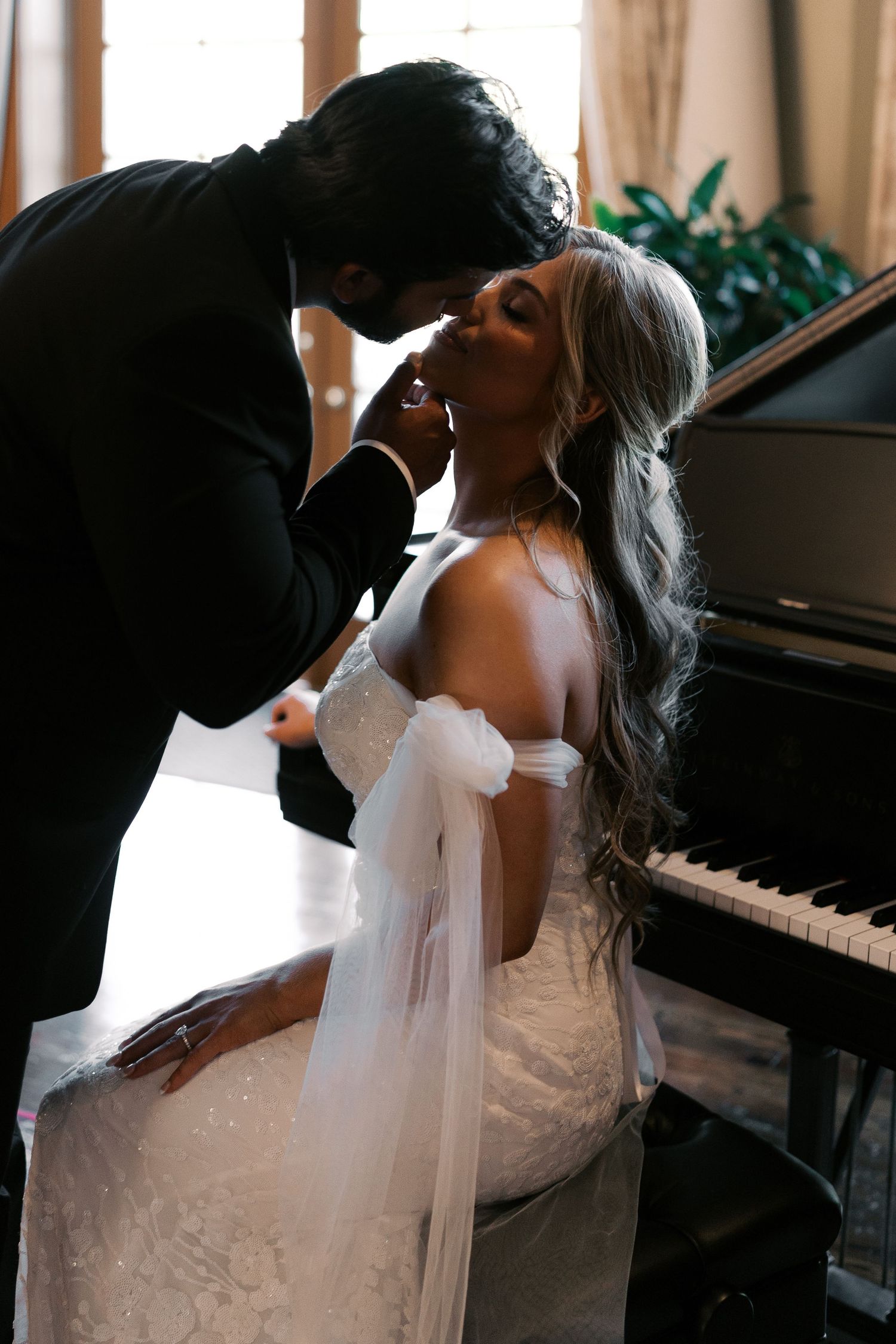 Intimate wedding portraits by a grand piano in warm natural light.
