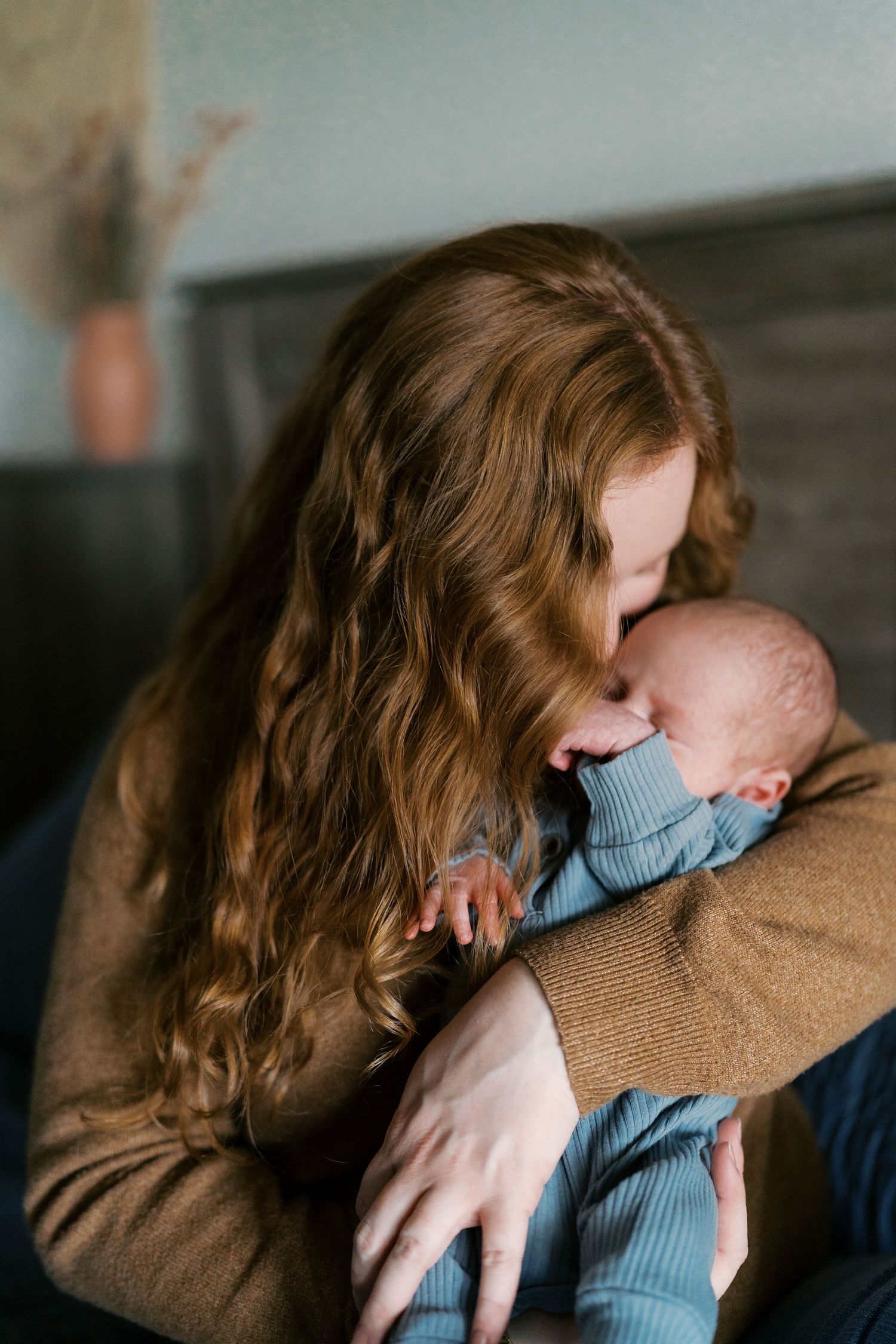 Intimate indoor portrait showing tender embrace in soft lighting.