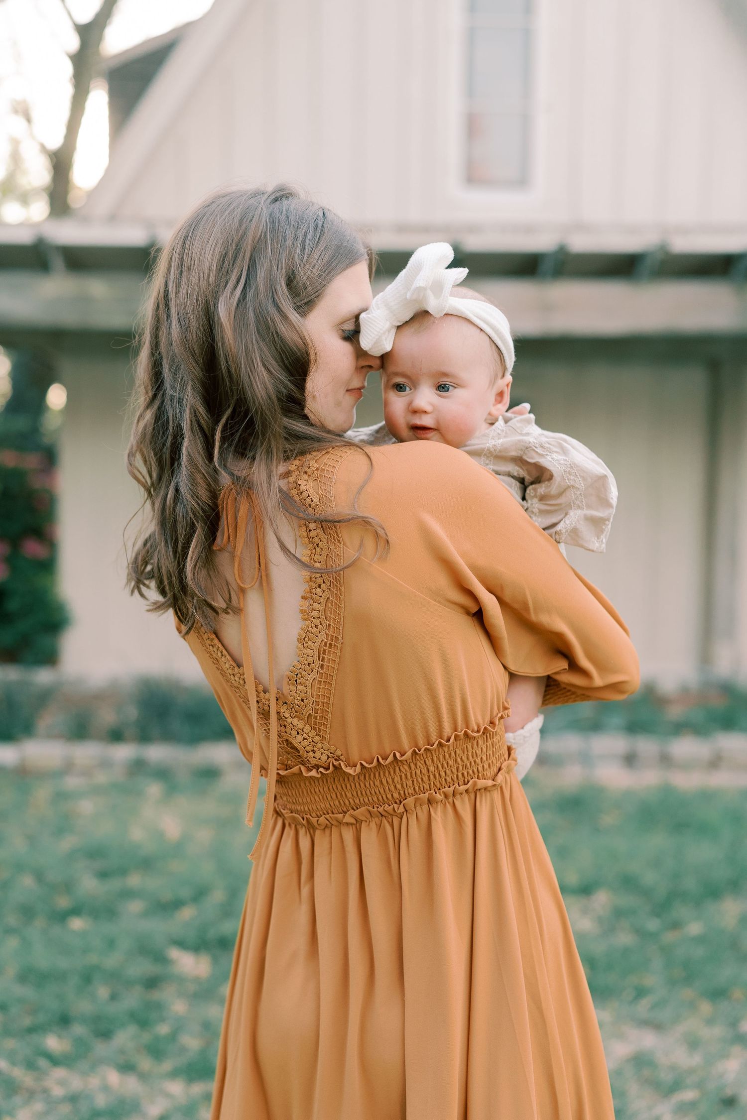 Rust-colored dress with delicate details shown from behind in an outdoor setting.