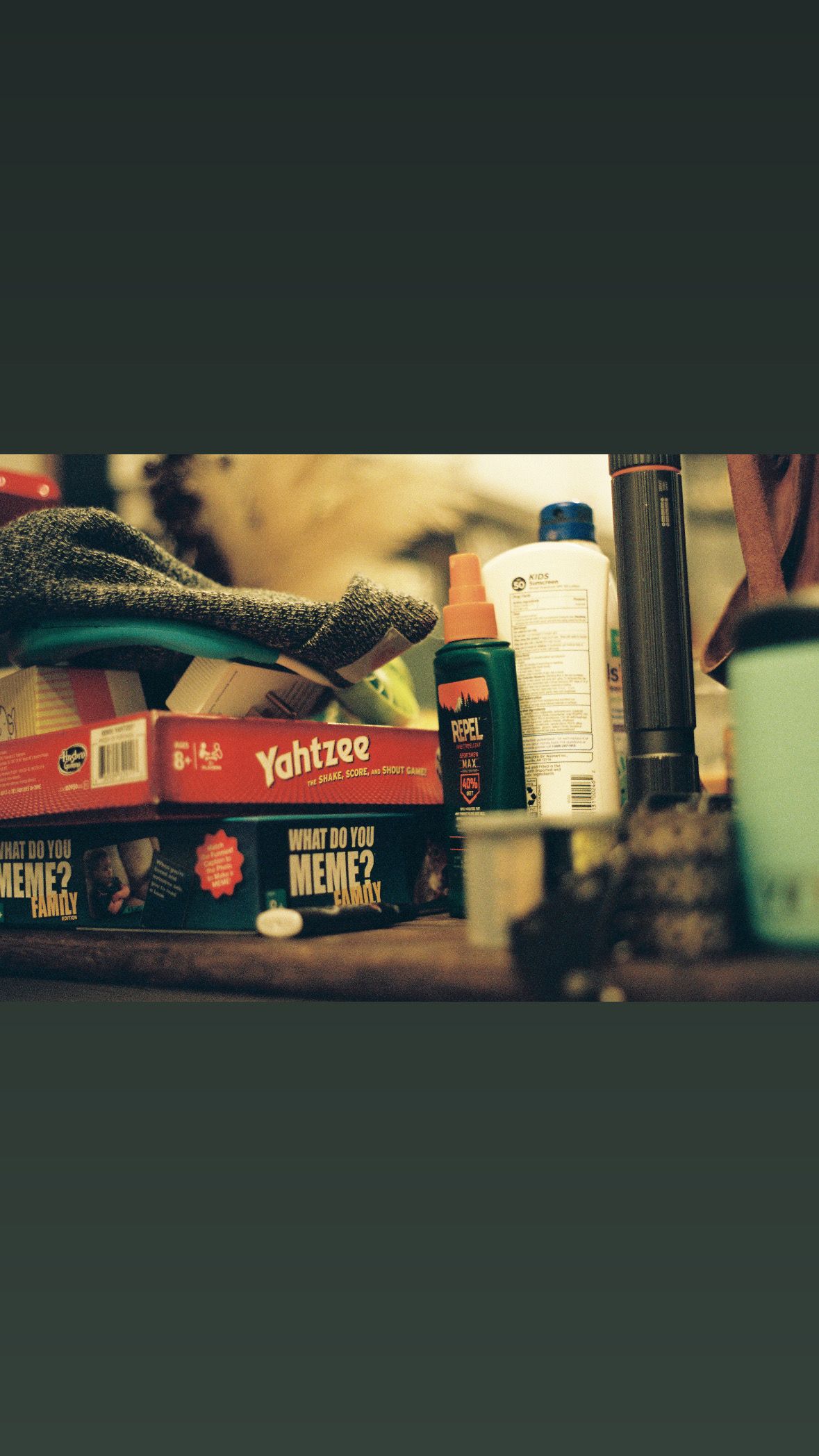 Close-up shot of household items and game boxes on a cluttered shelf.