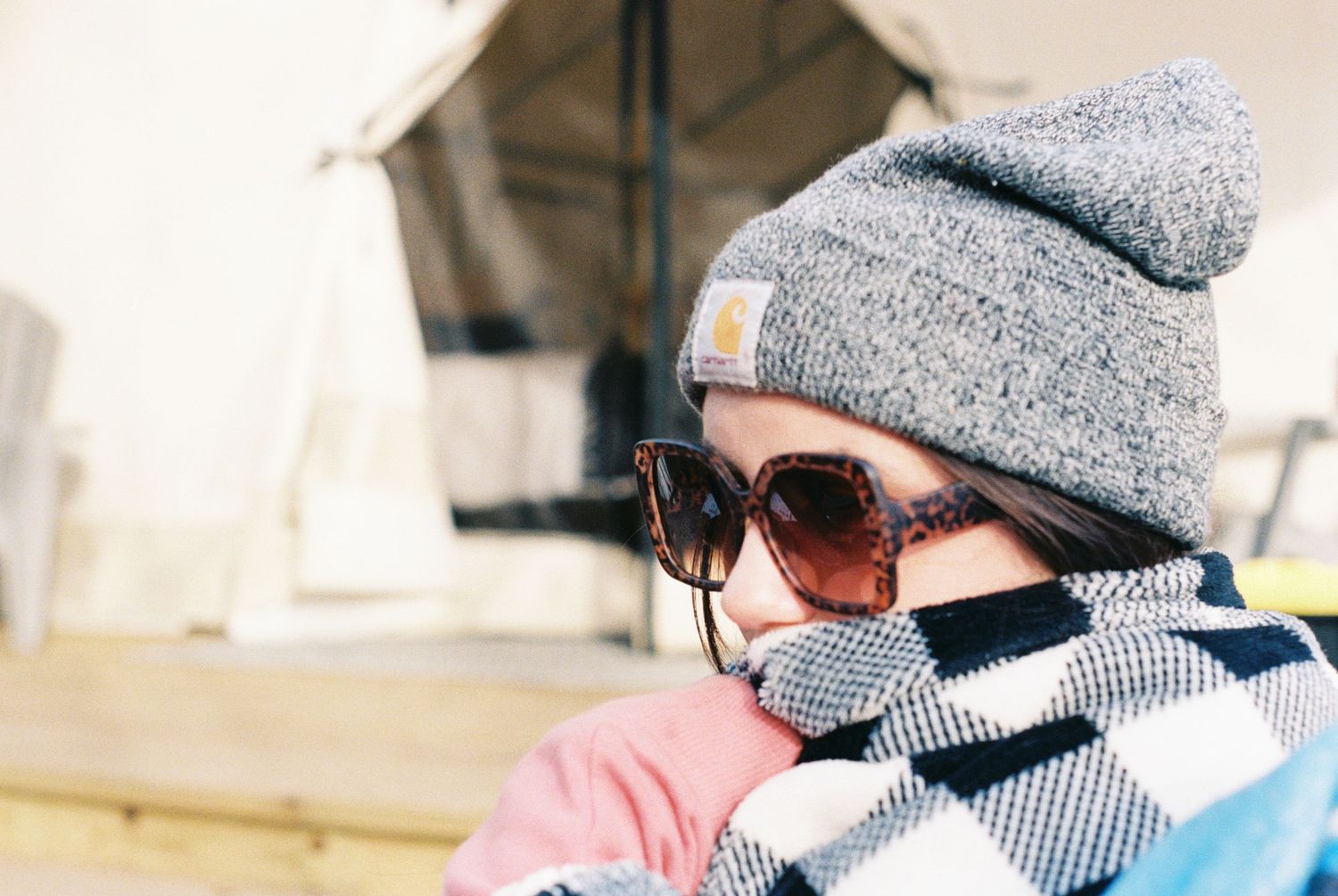 Winter scene with people wearing knit beanies and warm clothing outdoors.