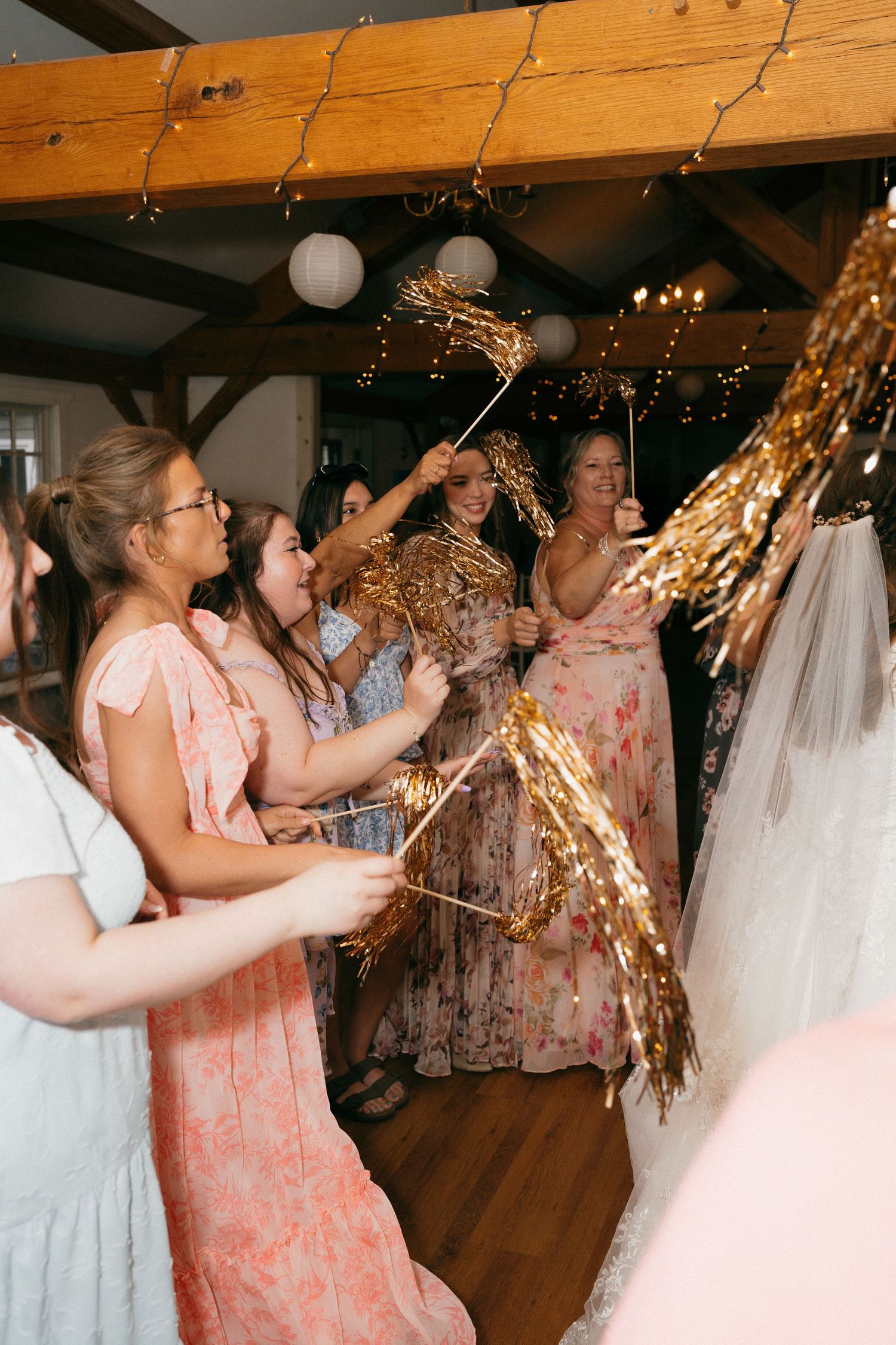 Wedding guests dancing and celebrating with sparklers during reception festivities.