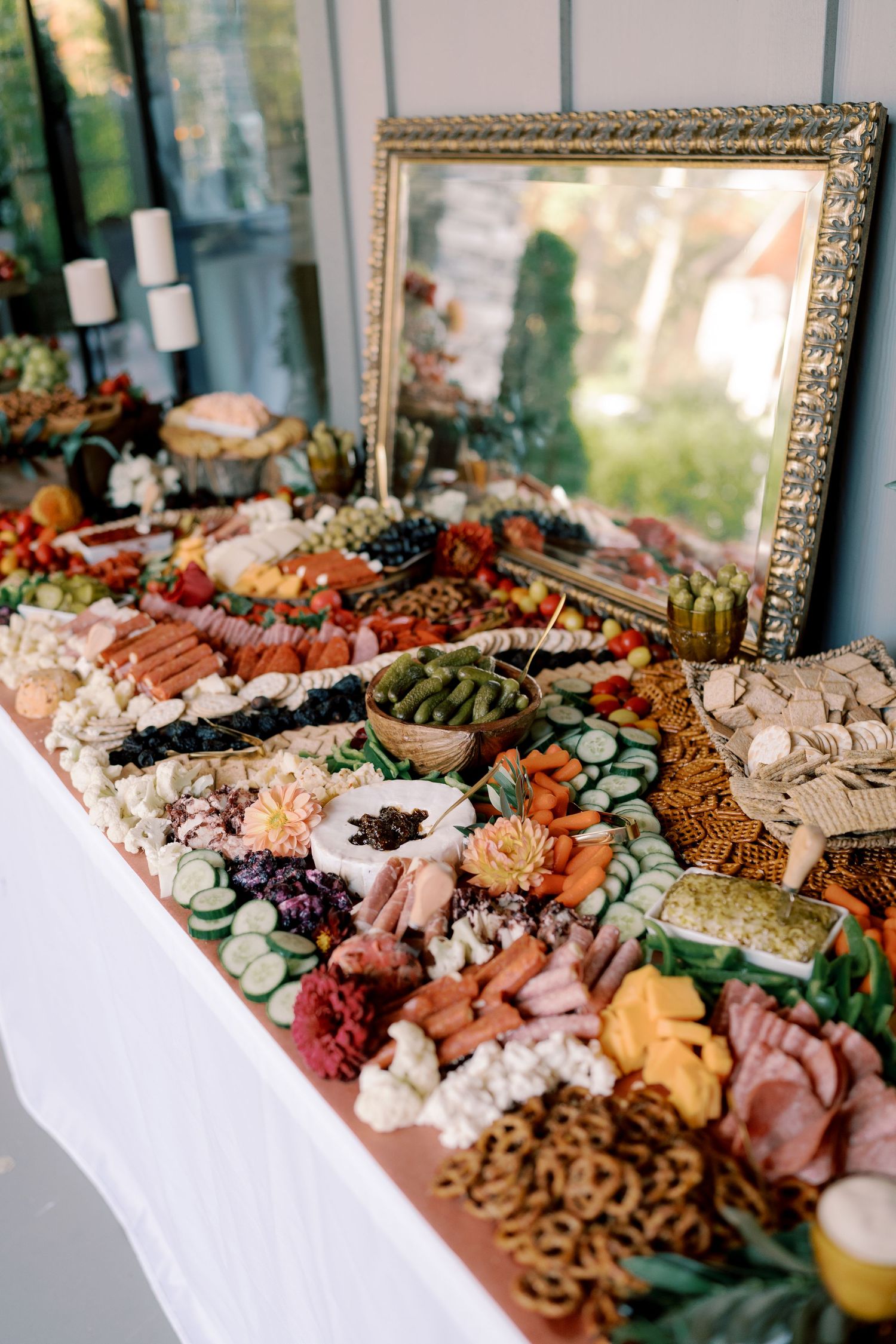 Elegant charcuterie board display with meats, cheeses, fruits and nuts at a wedding reception.