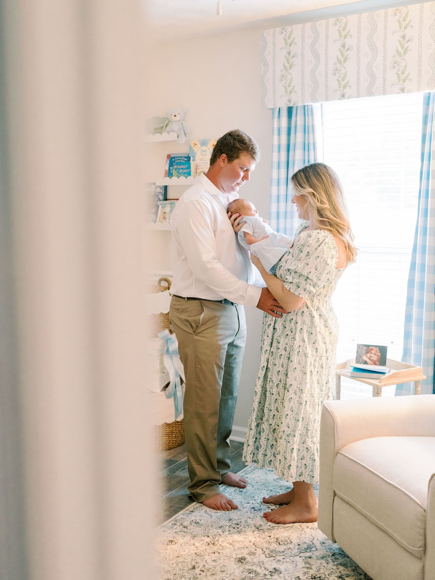 Couple shares an intimate moment in a bright nursery room with blue and white decor.