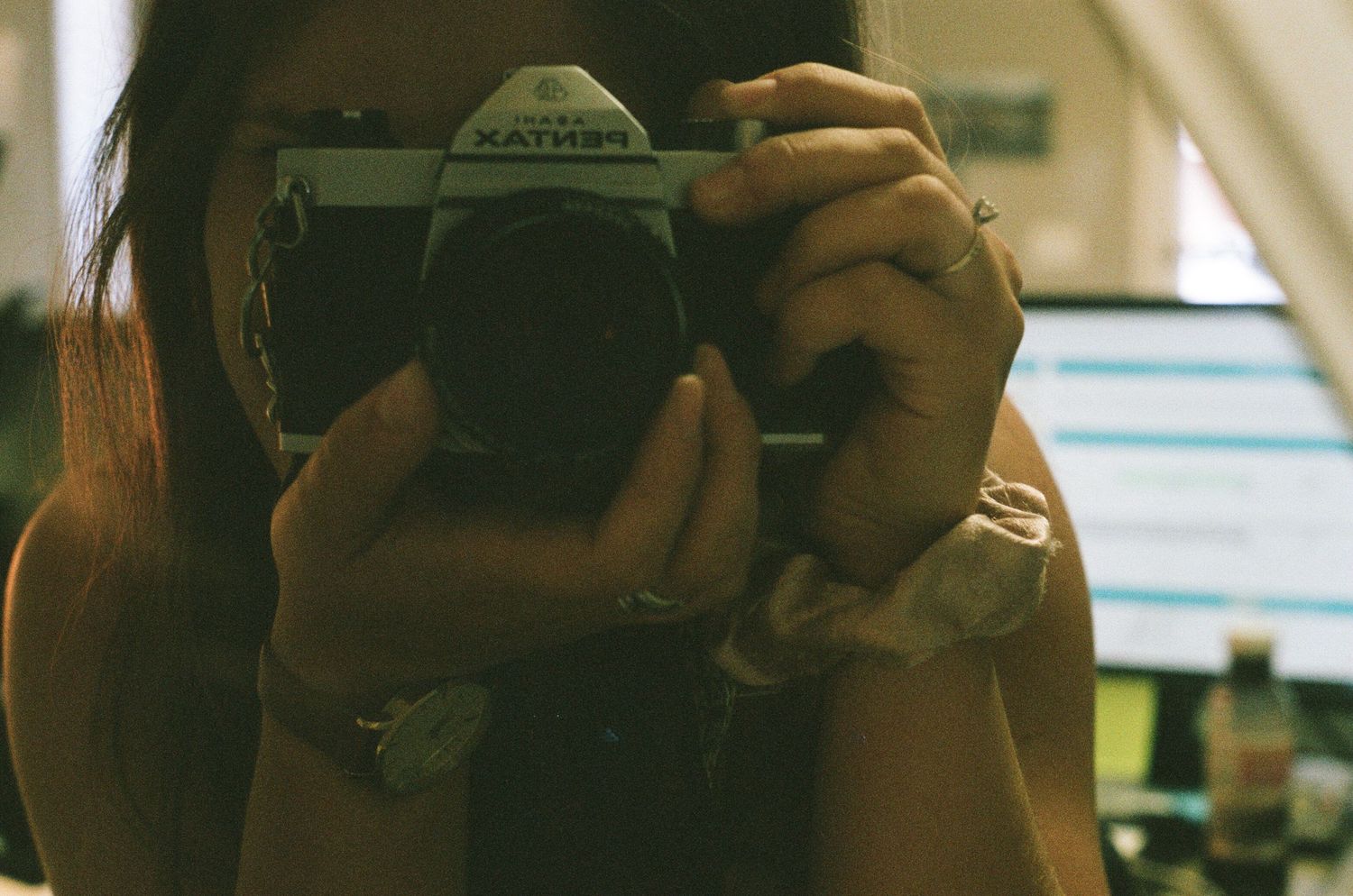 Hands hold a vintage camera against a blurred background.