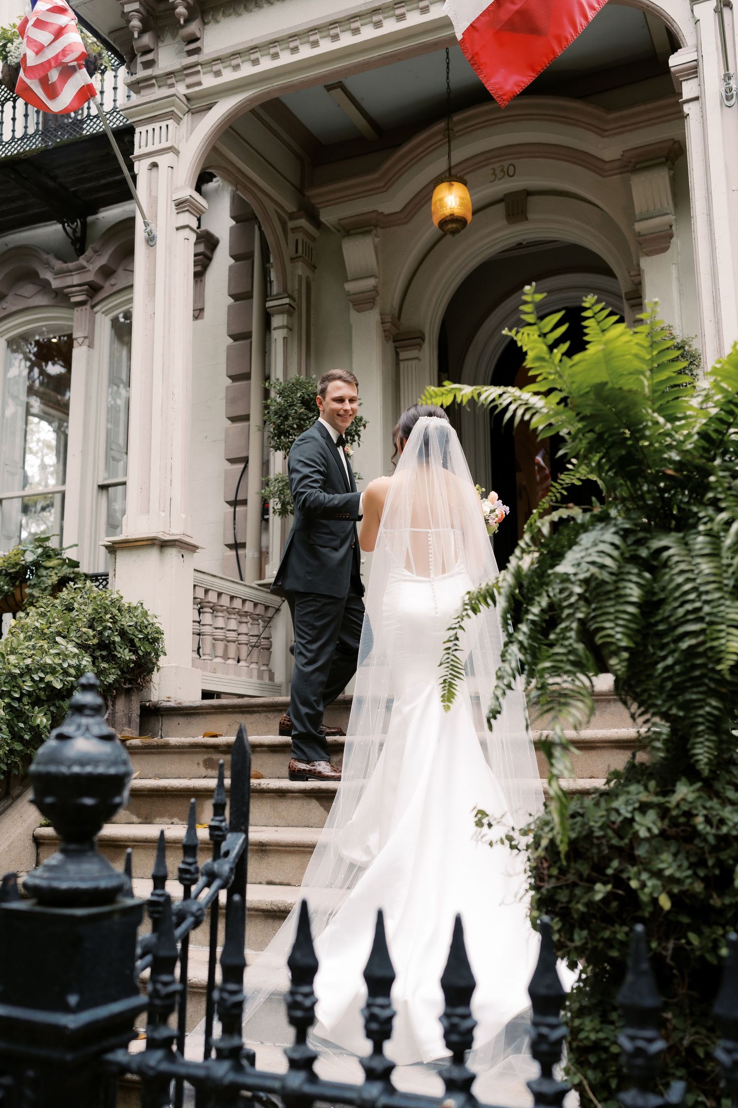 Wedding ceremony scene at ornate building with columns and architectural details.