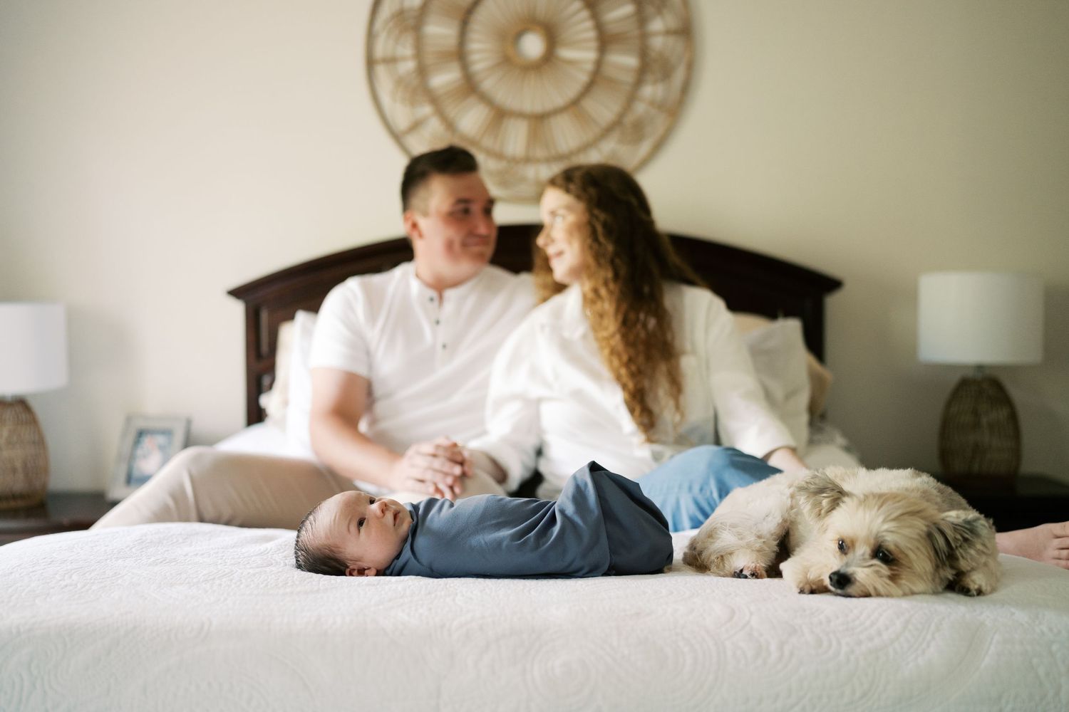 Family spending intimate moments together on bed with decorative wall art visible.