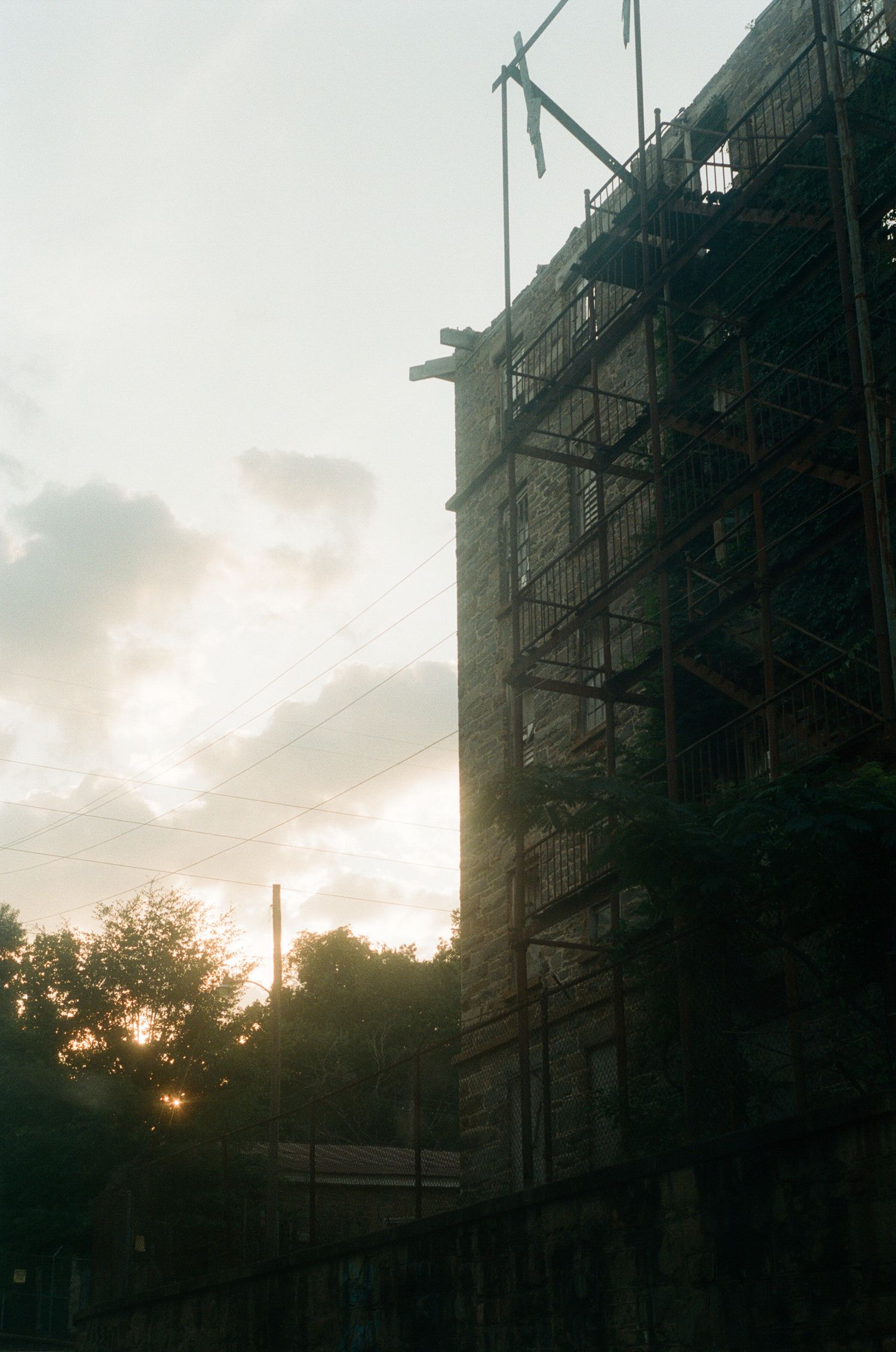 Construction scaffolding on building silhouetted against sunset sky.