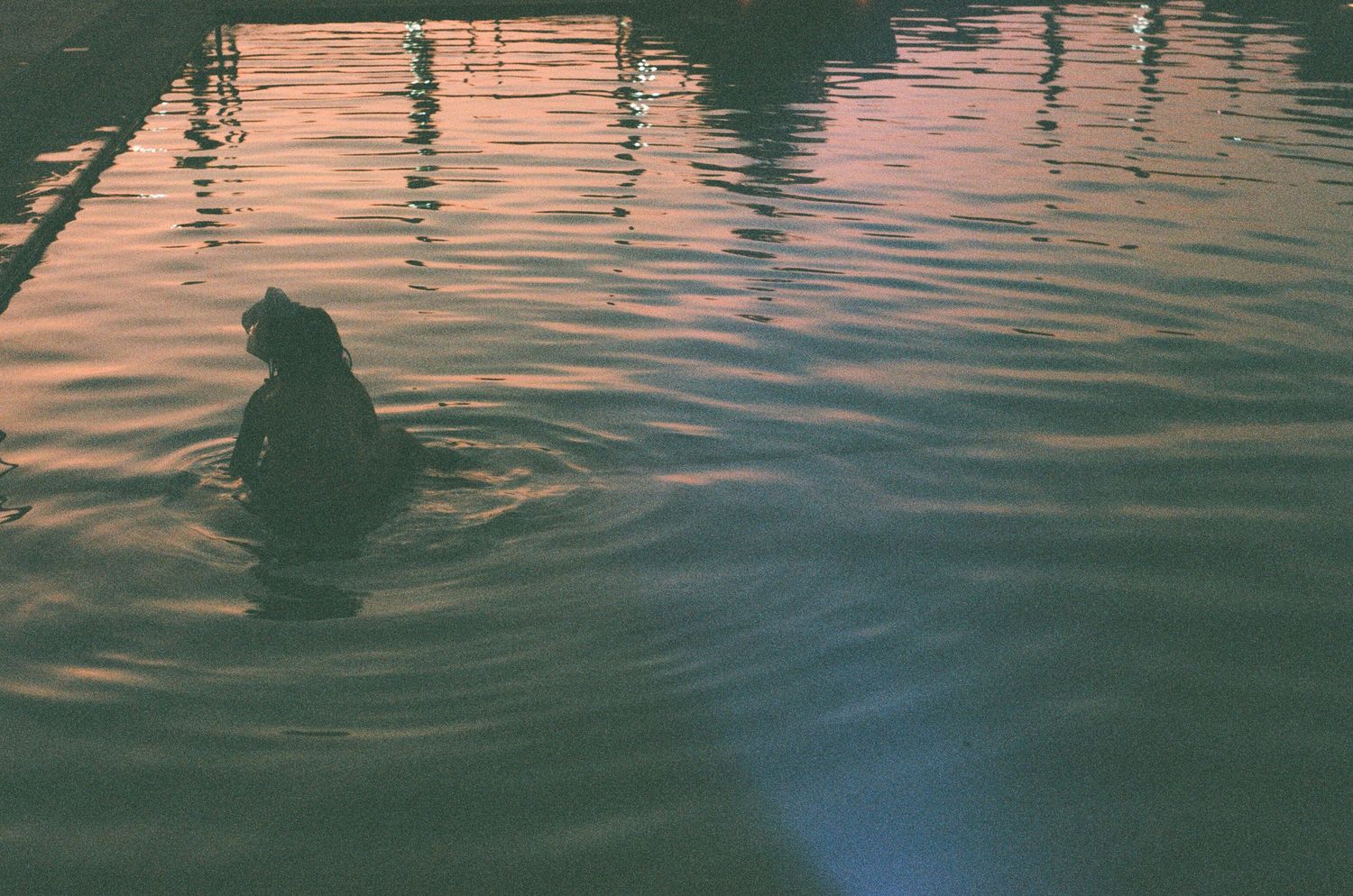 Rippling water surface reflecting sunset colors in muted tones.