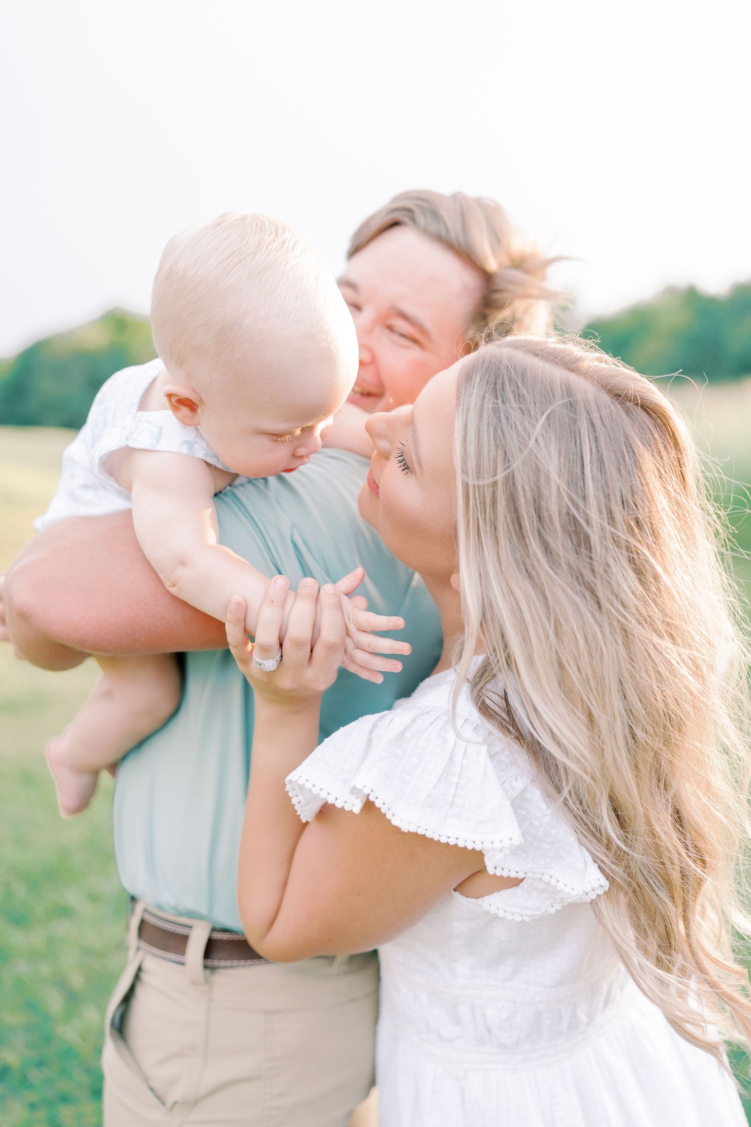 Intimate family moments captured in soft lighting during an outdoor photo session.