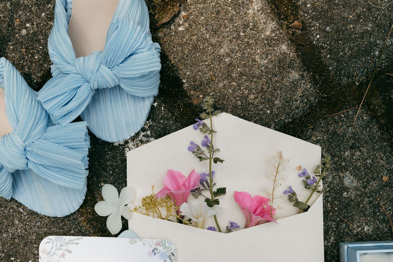 Light blue bow detail and floral elements arranged on a textured surface.