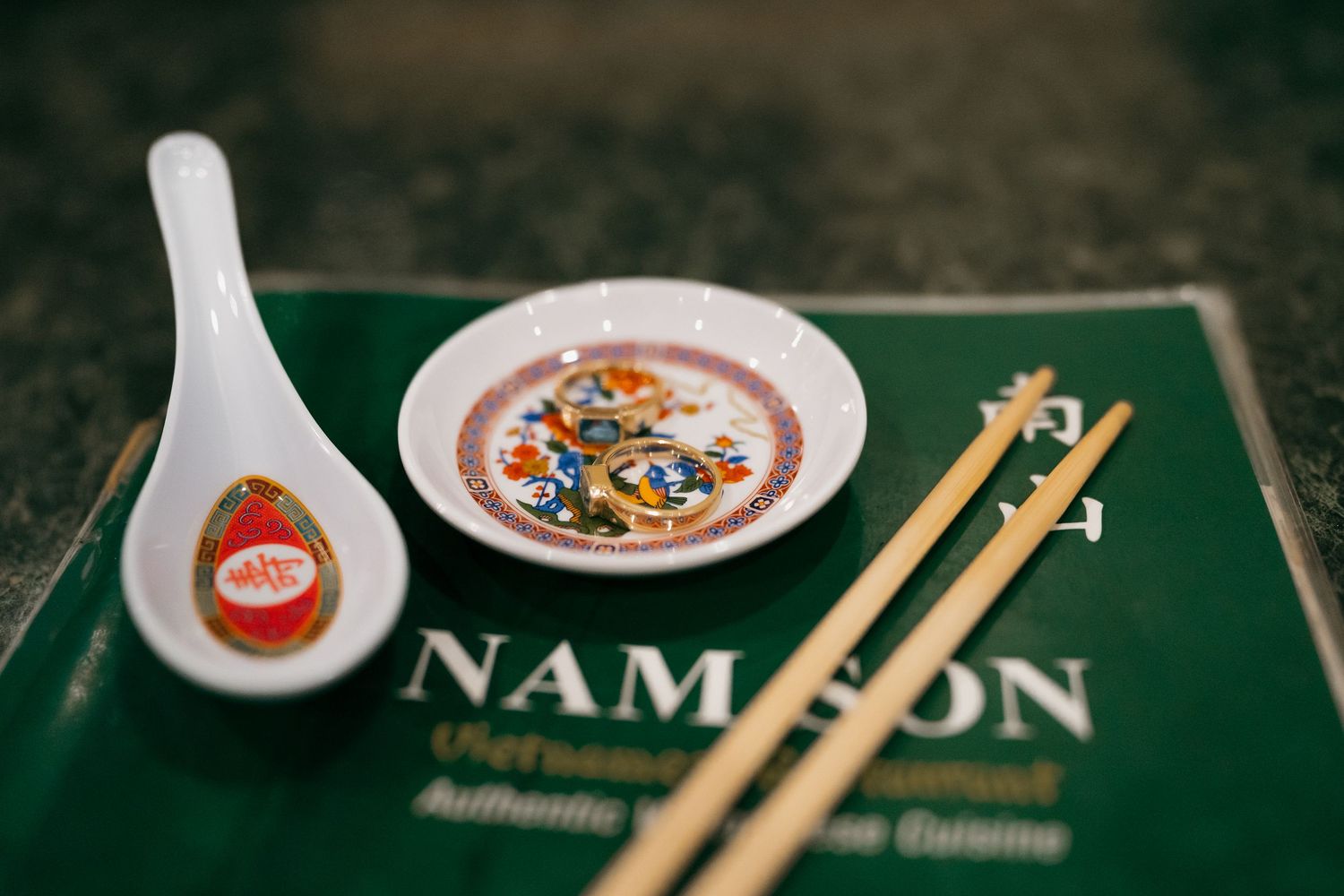 Asian restaurant table setting with chopsticks and branded placemats.