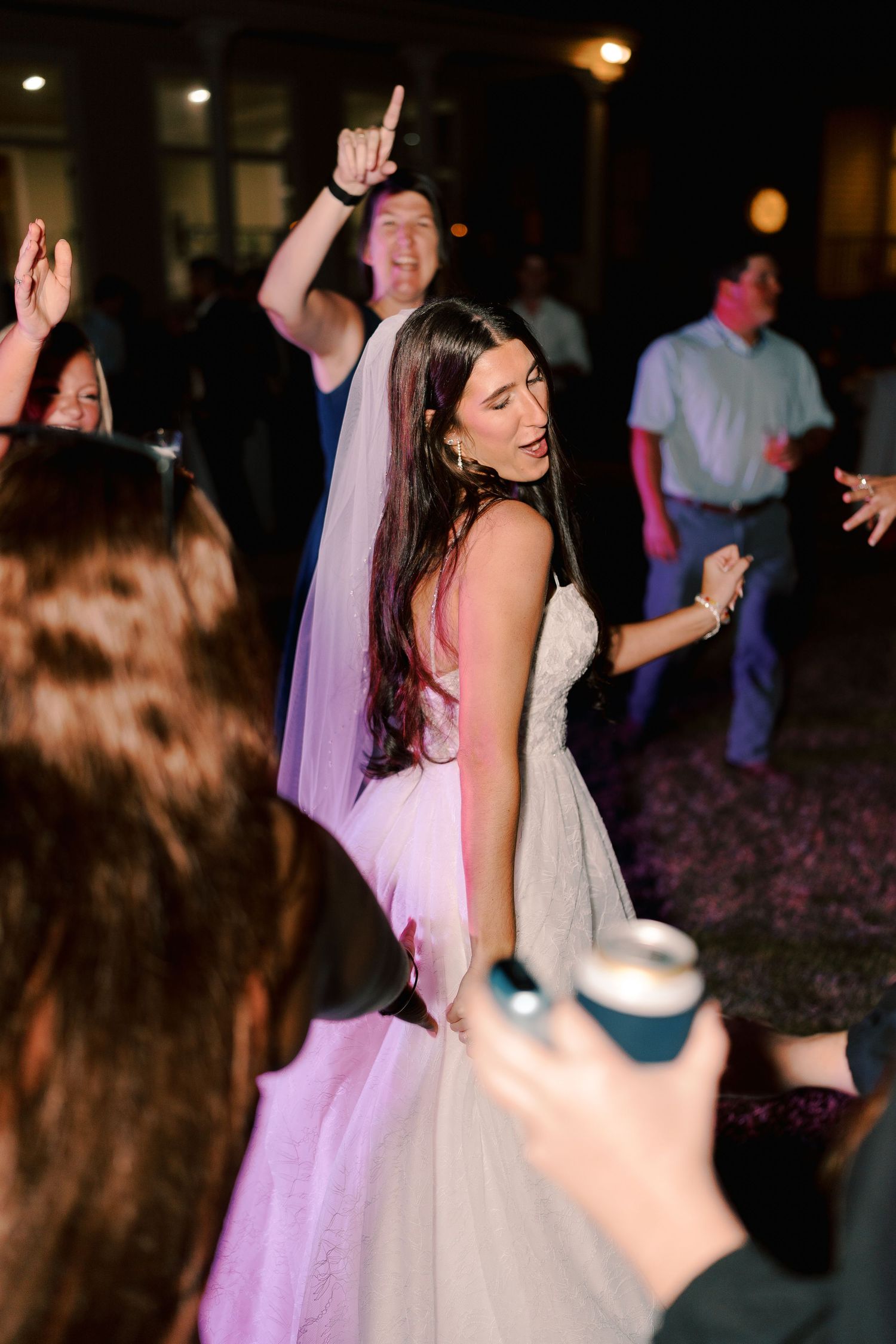 Wedding celebration with dancing and festivities under evening lights.