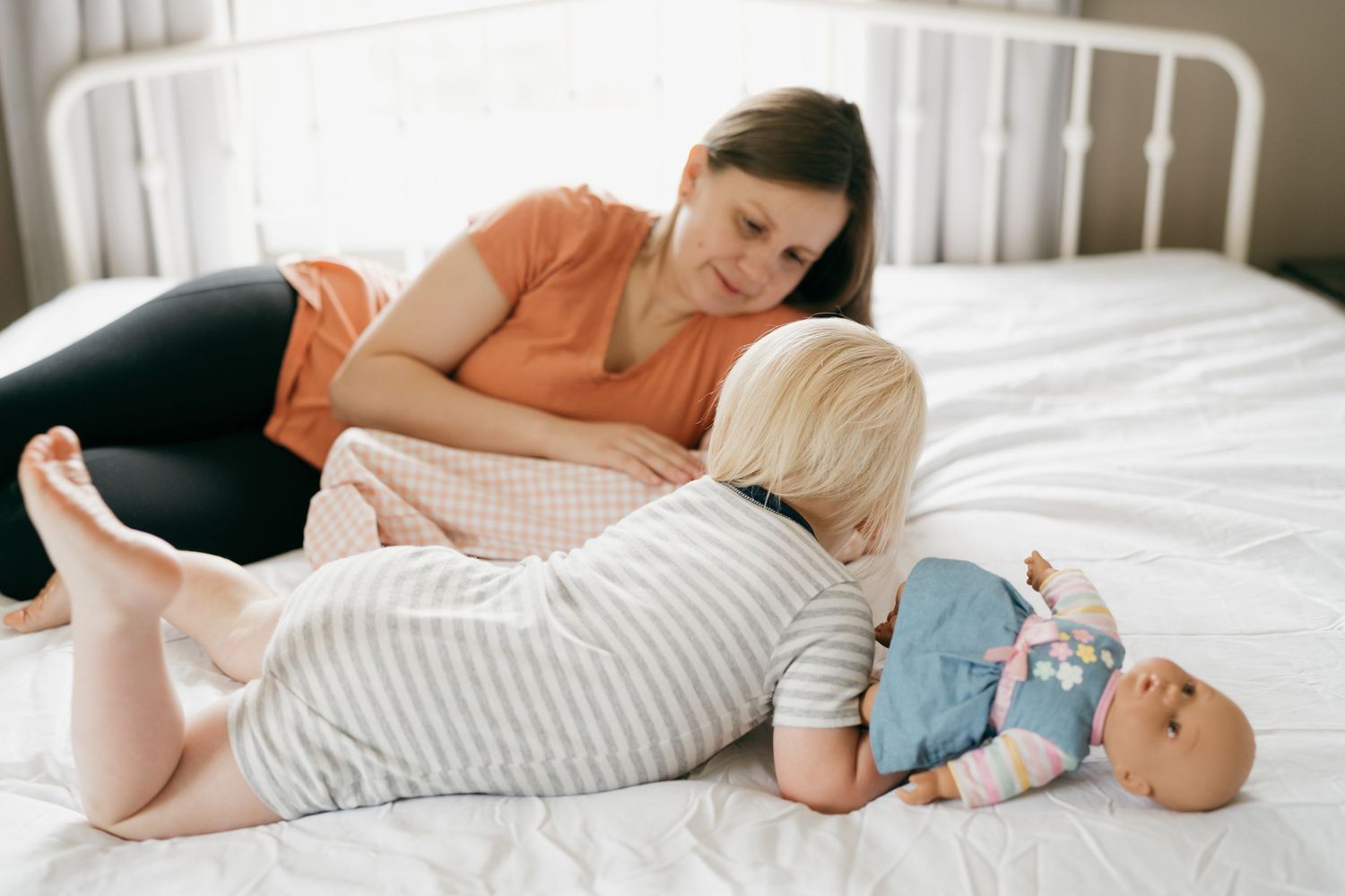 Family sharing sweet moments together on white bed.