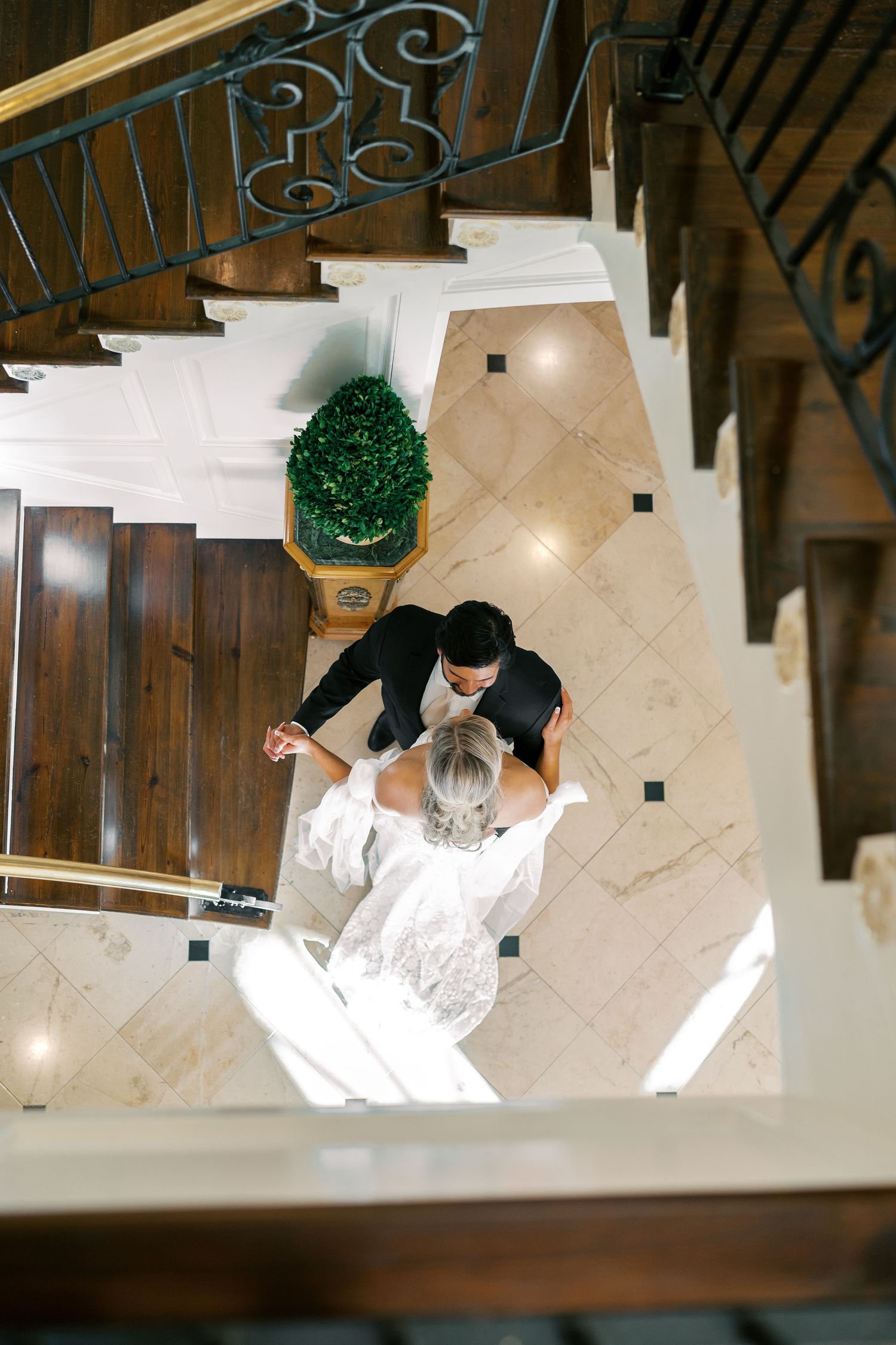 Bird's eye perspective of romantic wedding moments on an elegant staircase.