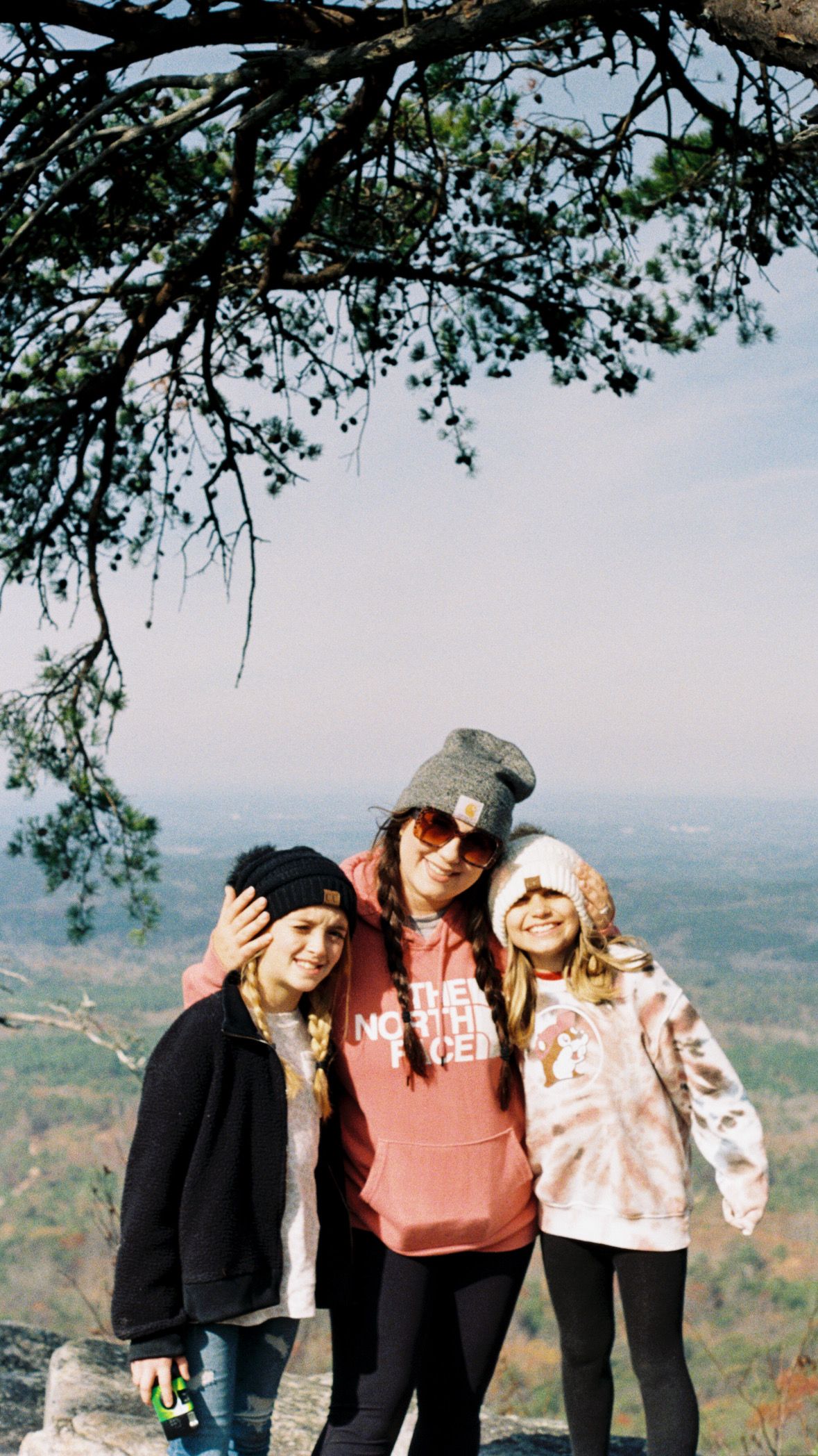 Friends posing together on a hilltop overlook during autumn.
