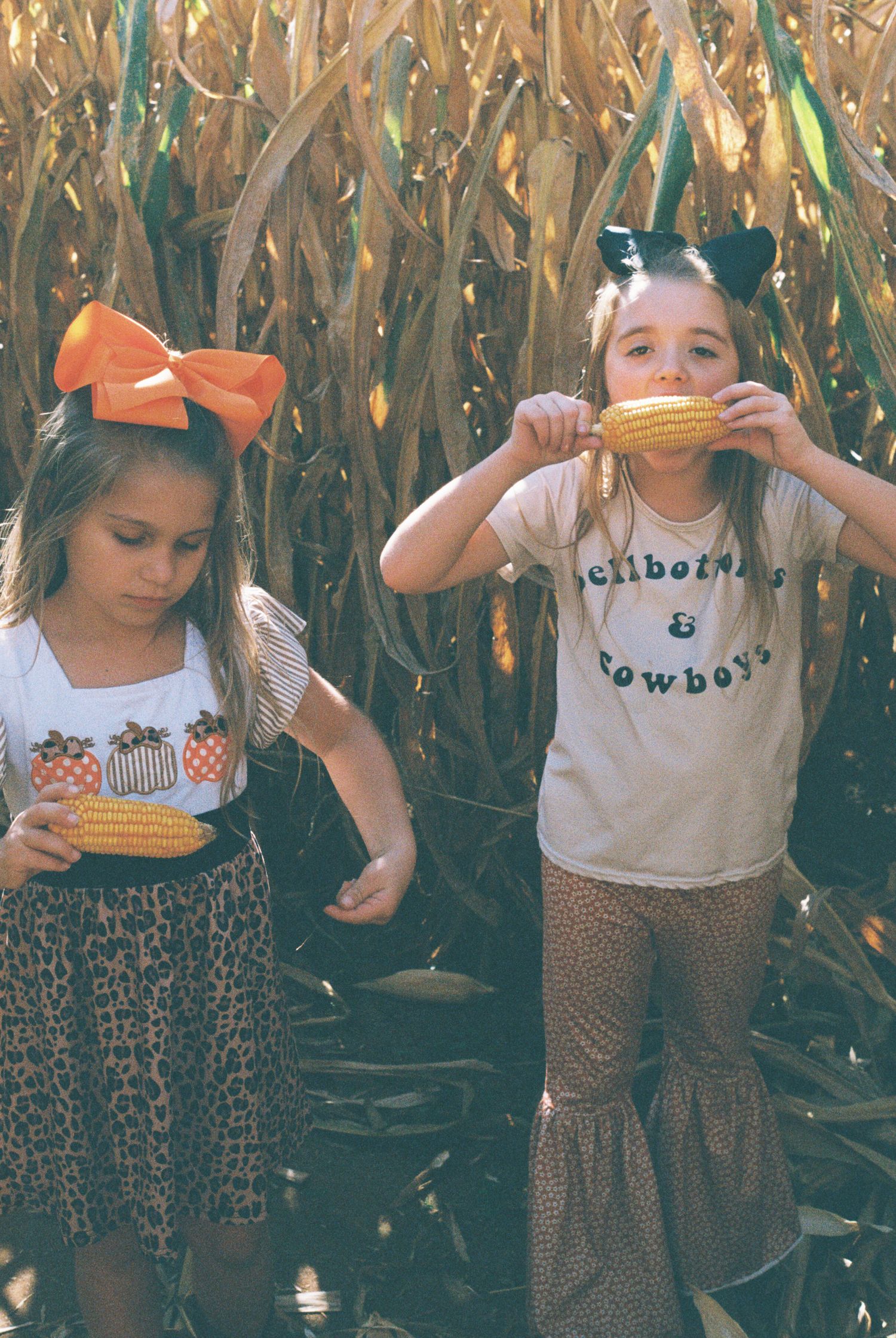 Group wearing matching leopard print pants and t-shirts posing in a cornfield.