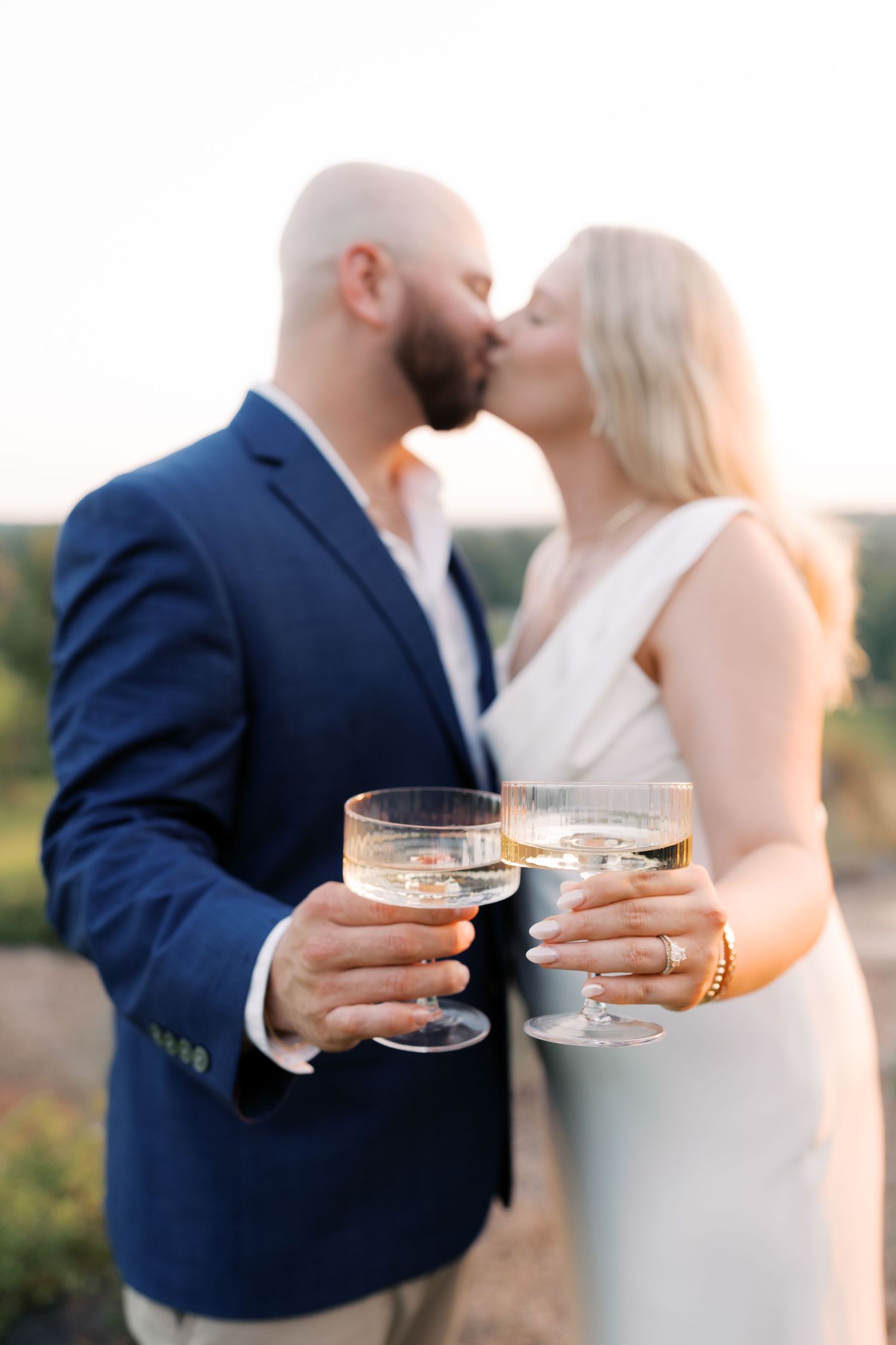 Couple toasting with champagne glasses during romantic sunset moment.