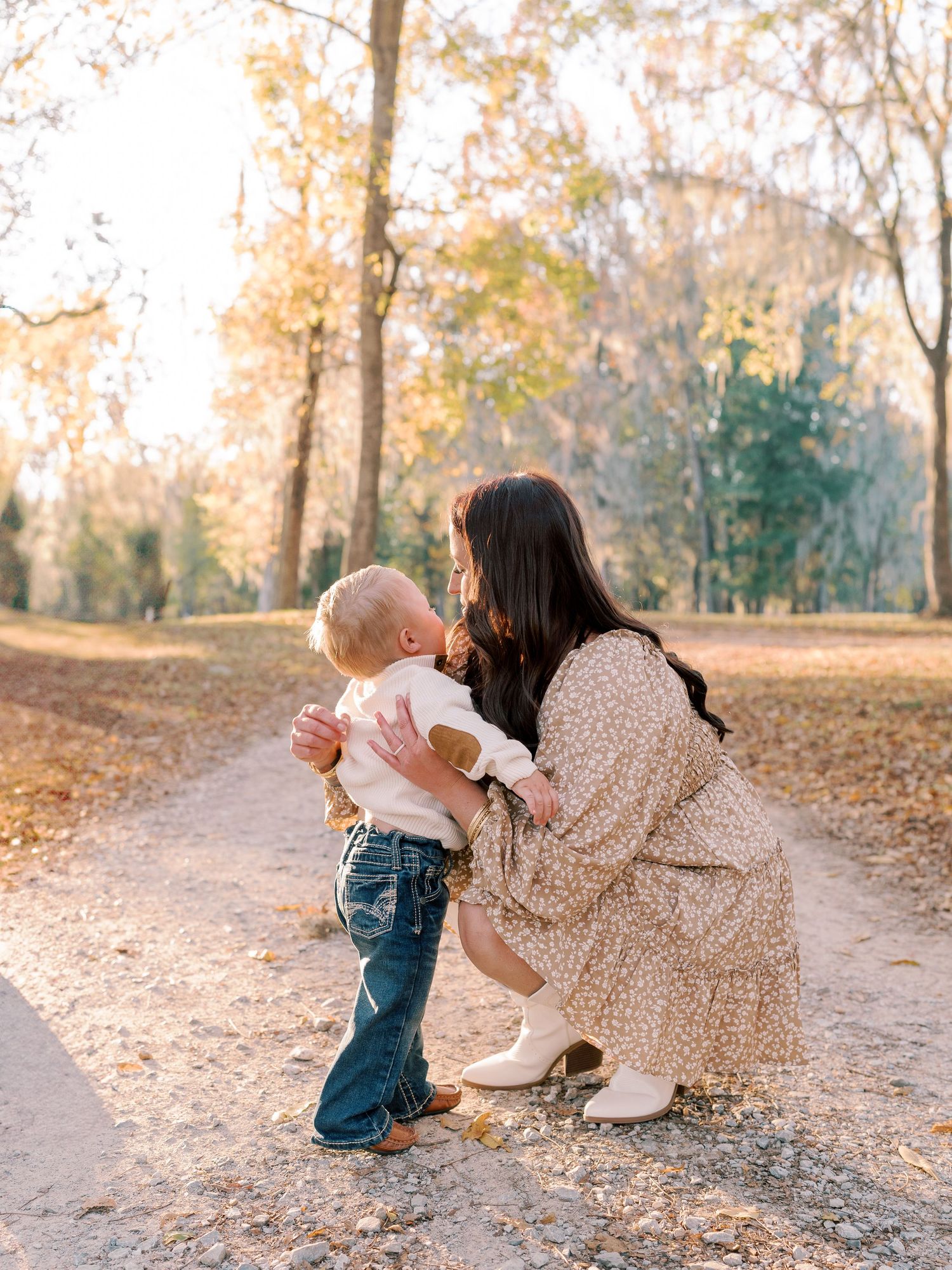 Sweet interaction between parent and child on autumn path.