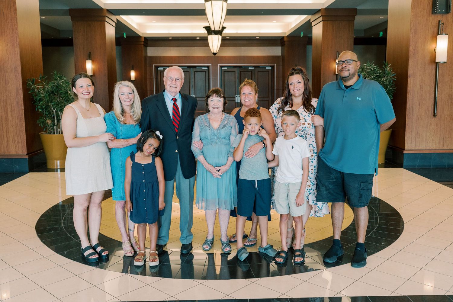 Group photo of family members standing together in formal lobby setting.